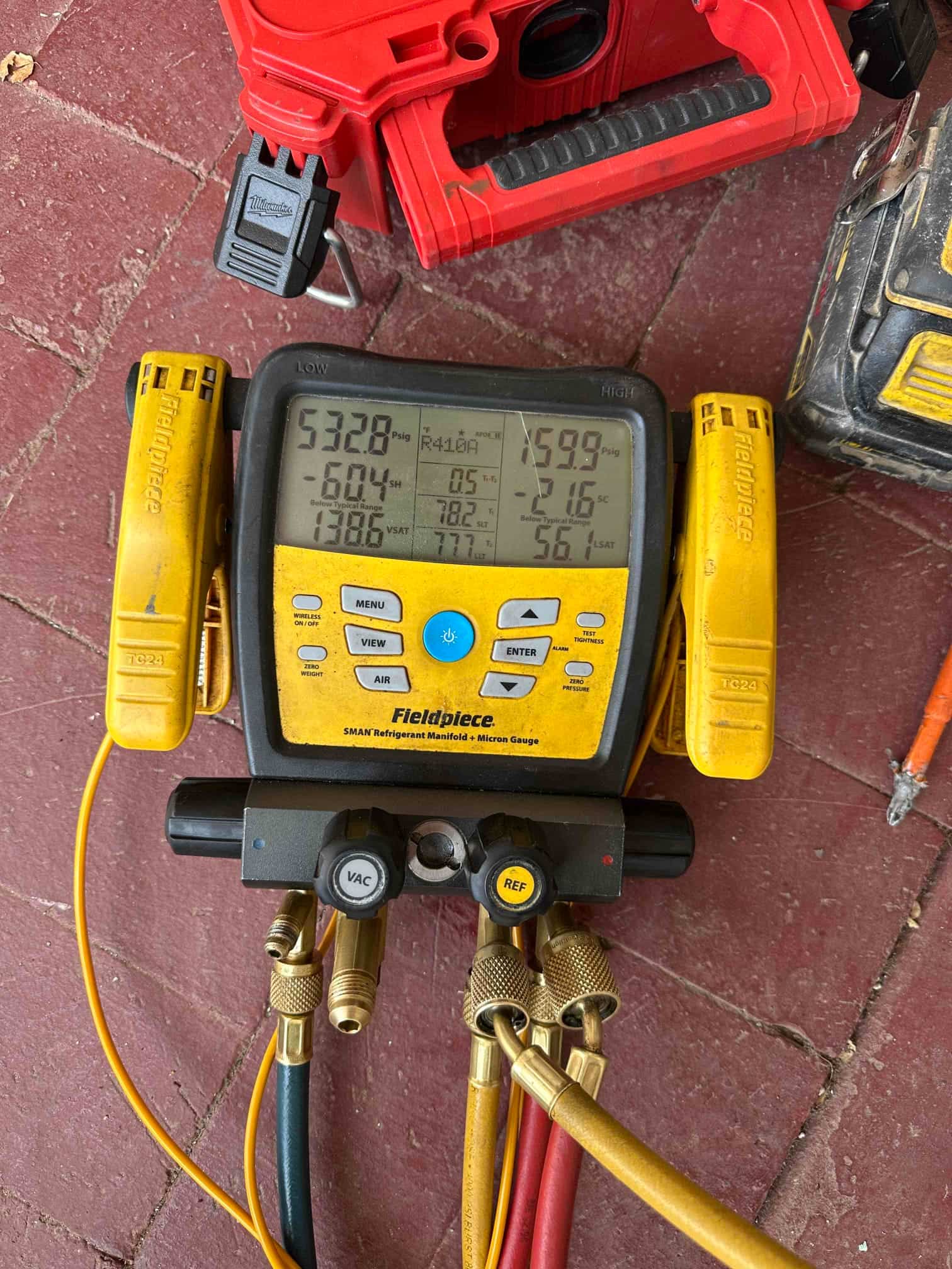 Digital manifold shows system operating pressures with clamps attached during commissioning of the newly installed split system.