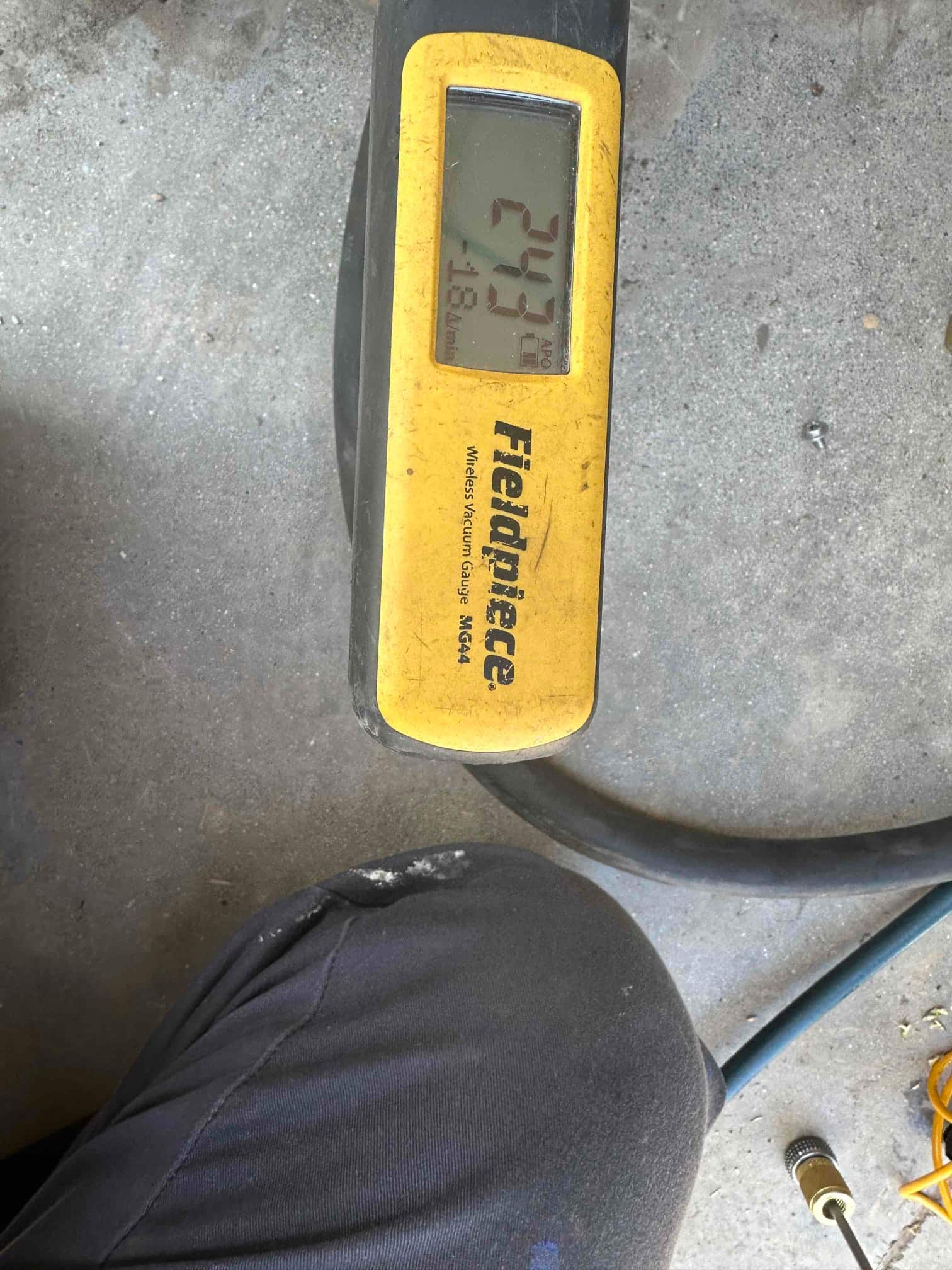 Digital micron gauge shows a deep vacuum at 243 microns during system evacuation before refrigerant charging.