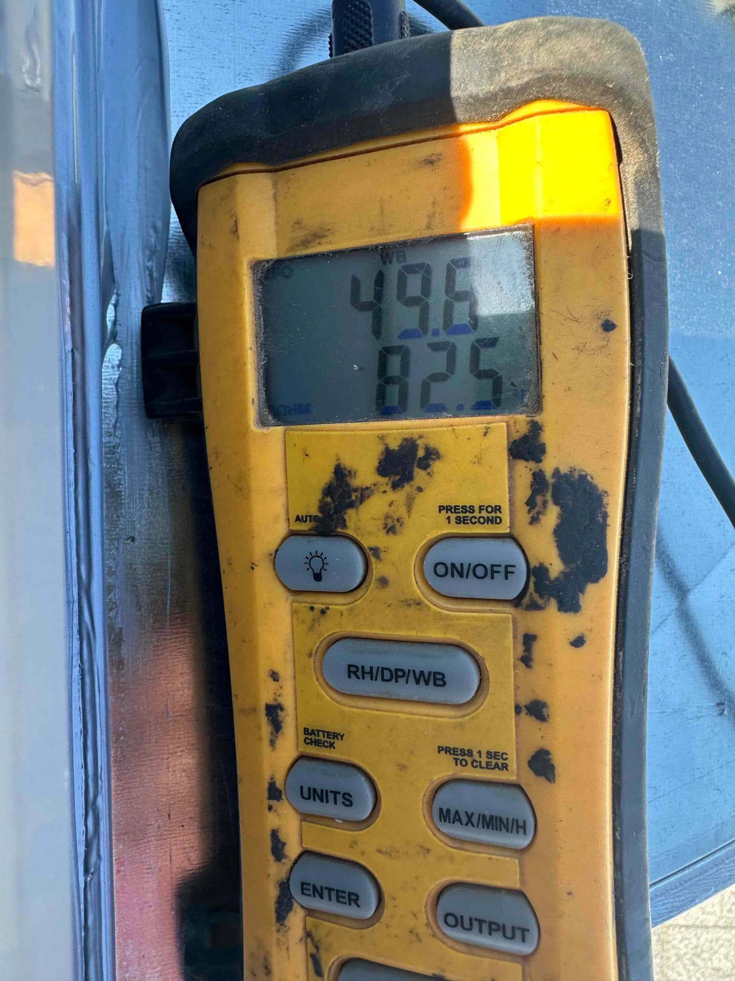 Digital thermometer displays 49.6 degrees for supply air and 82.5 degrees for return air during system commissioning.