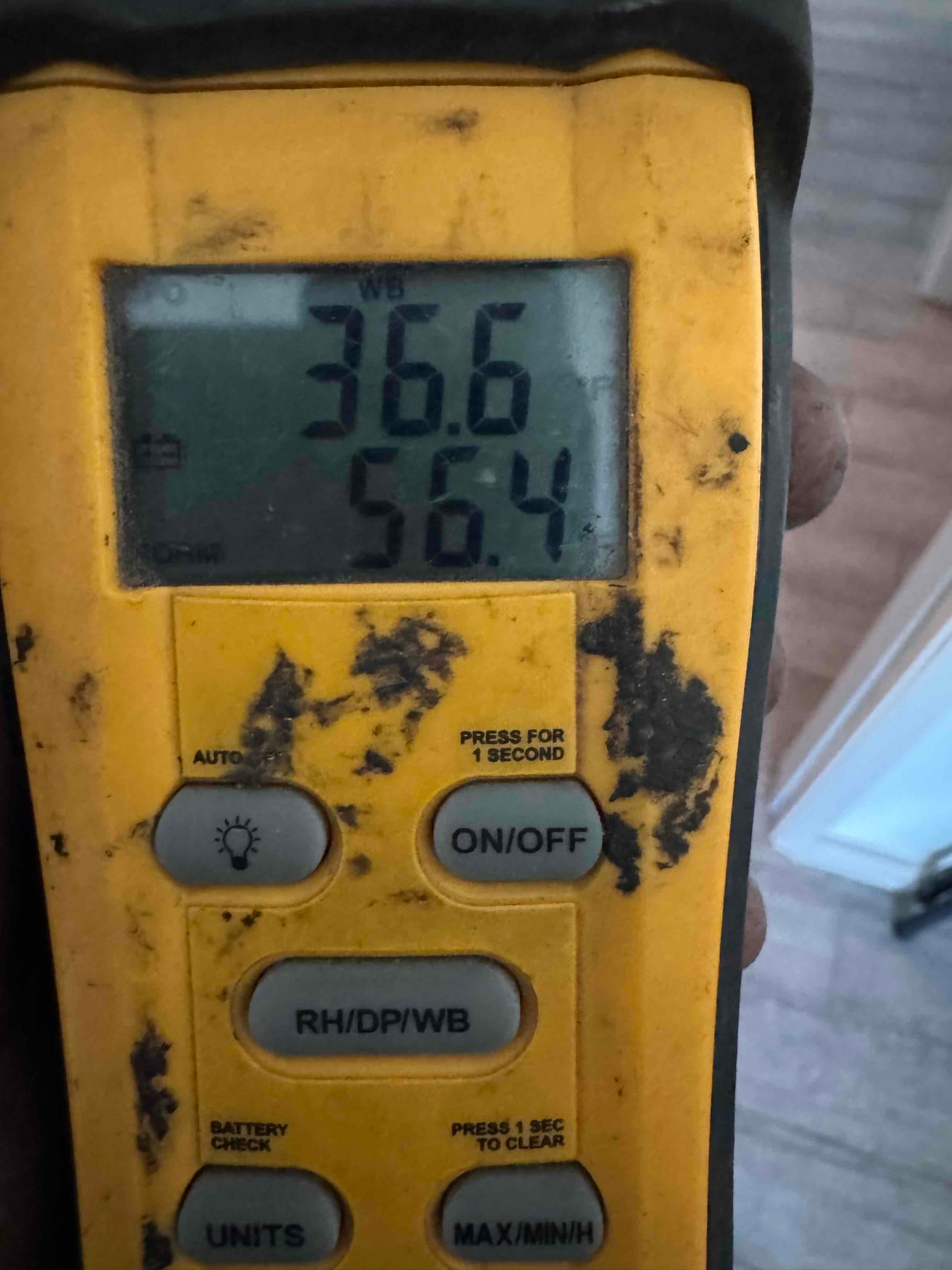 Digital thermometer displays 56.4 degrees Fahrenheit air temperature during commissioning check of the HVAC system.