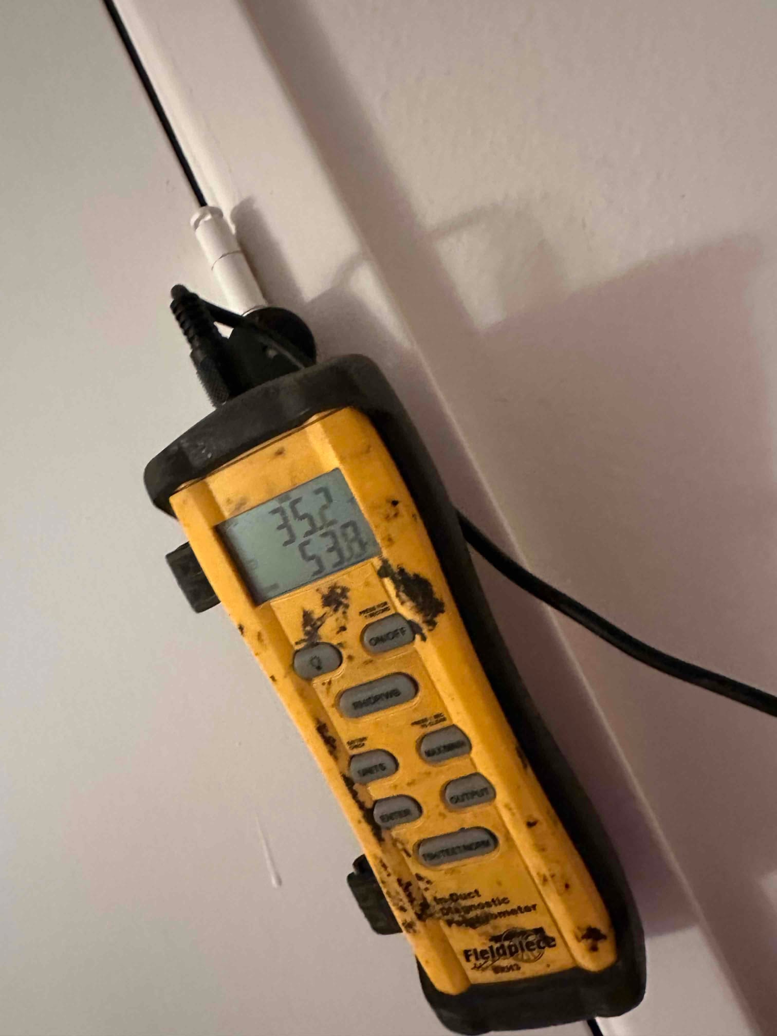 Digital thermometer displays 75.2°F and 53.8°F during air temperature checks for return and supply measurements.