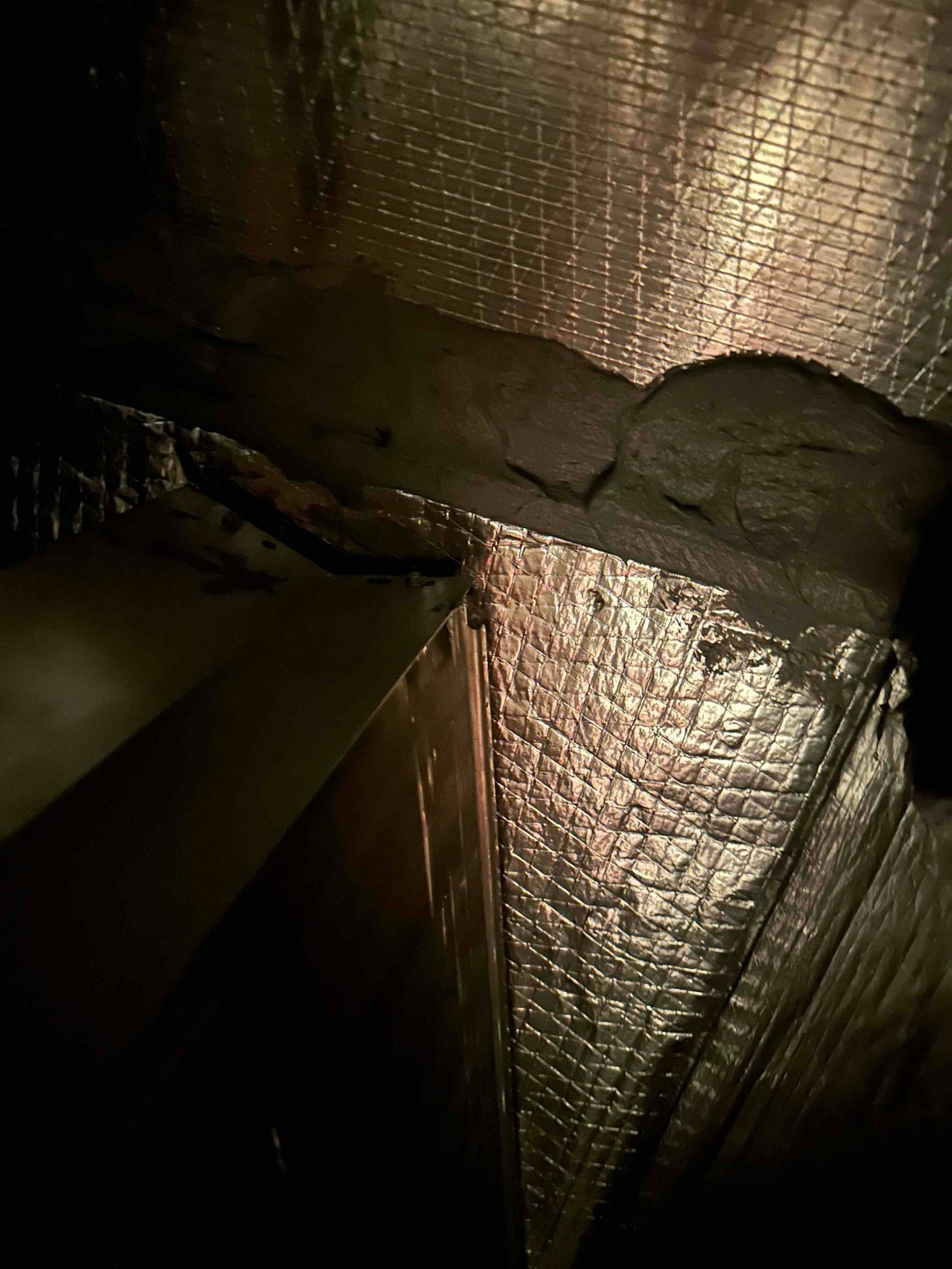 Ductboard seam sealed with mastic at a corner joint, improving the air-tightness of the new HVAC installation.