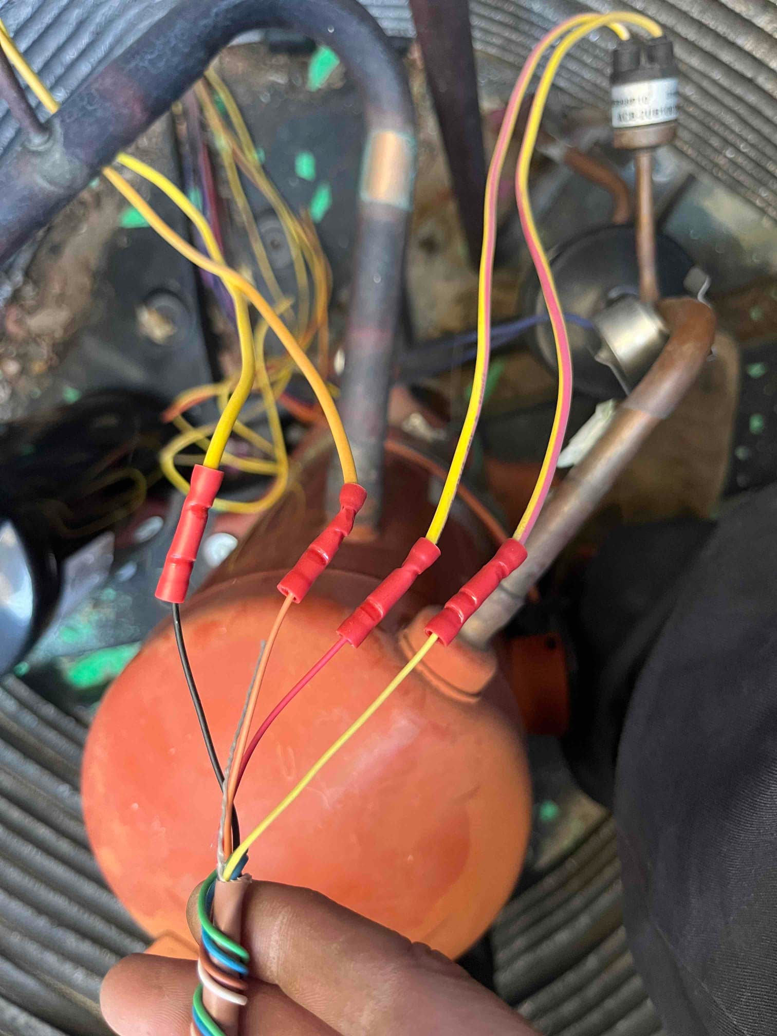 HVAC compressor wiring repair shown with multiple yellow conductors joined using red insulated crimp butt connectors.