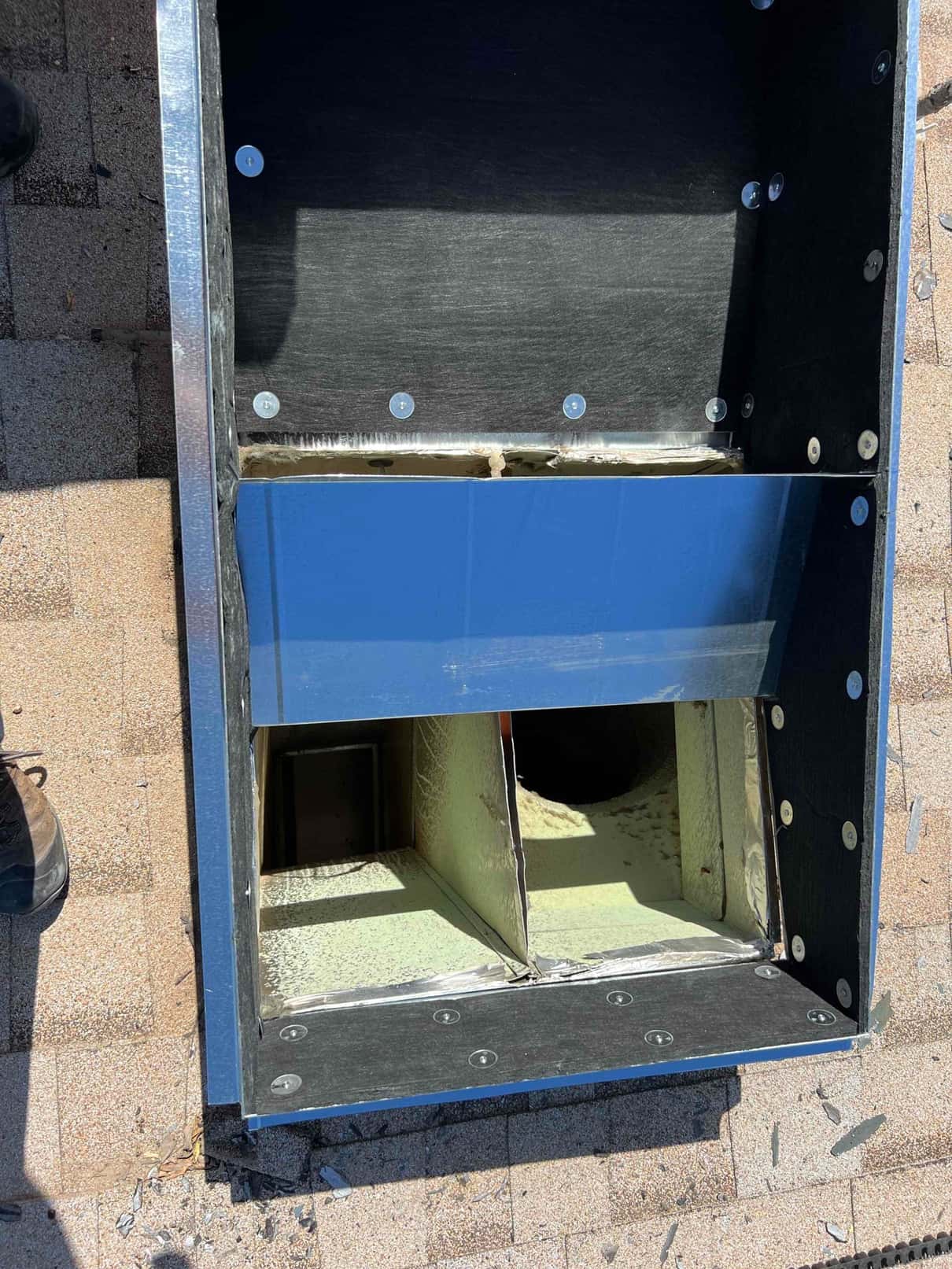 Metal rooftop curb with insulated supply and return openings prepared for package unit installation, fastened and sealed at the base.