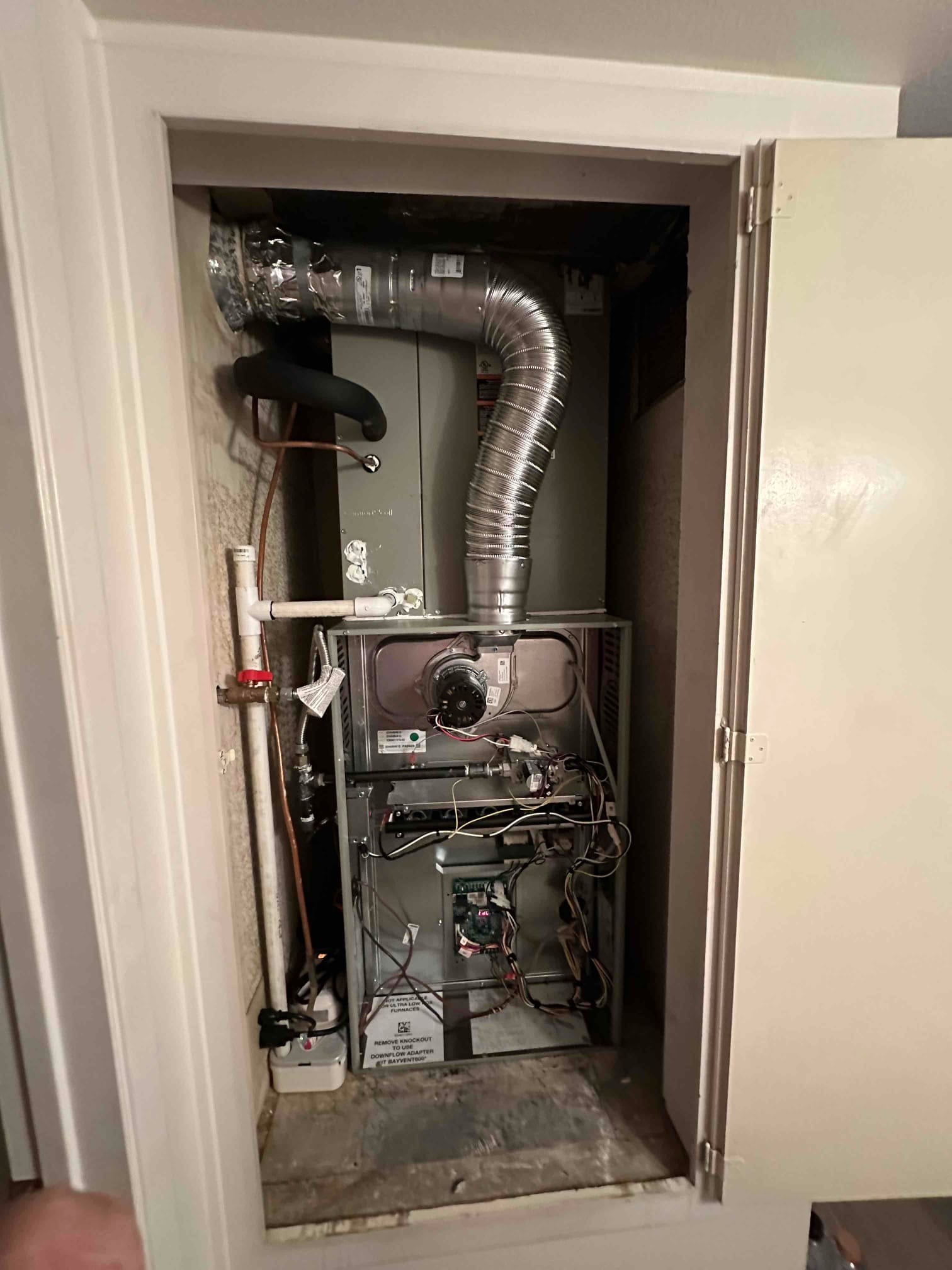 New furnace and evaporator installed in a closet, with venting, condensate drain, copper line set, and control wiring visible.