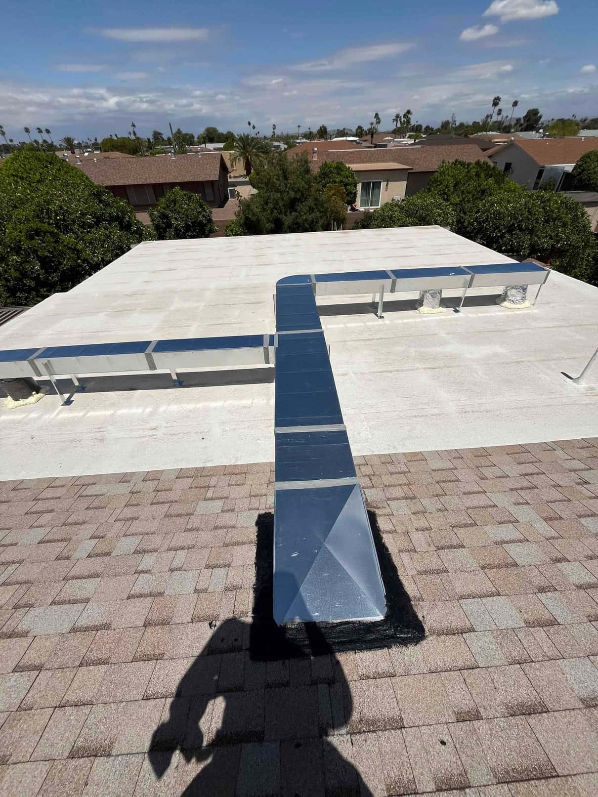 New rooftop sheet-metal ductwork runs across the roof with sealed roof penetration and transitions, showing clean installation routing.