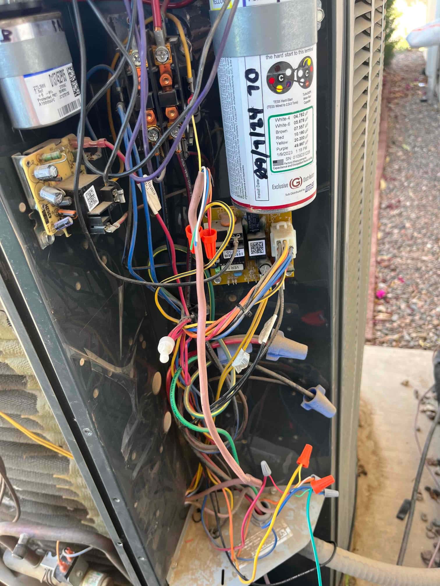 Outdoor condenser control compartment open, showing pressure switch wiring with multiple wire nuts and control board connections.