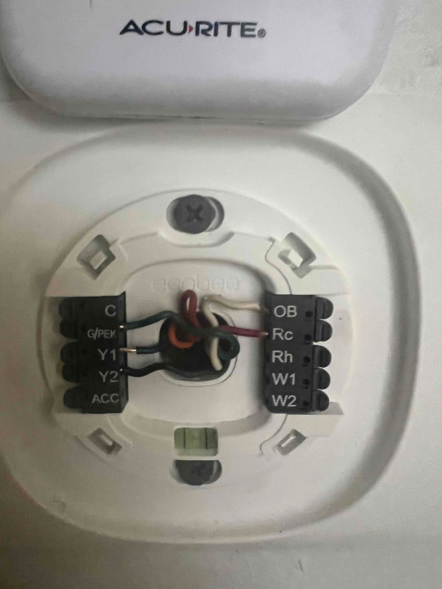 Thermostat wall plate wired to HVAC control terminals, showing connected C, G, Y1, W1, and R circuits for system control.