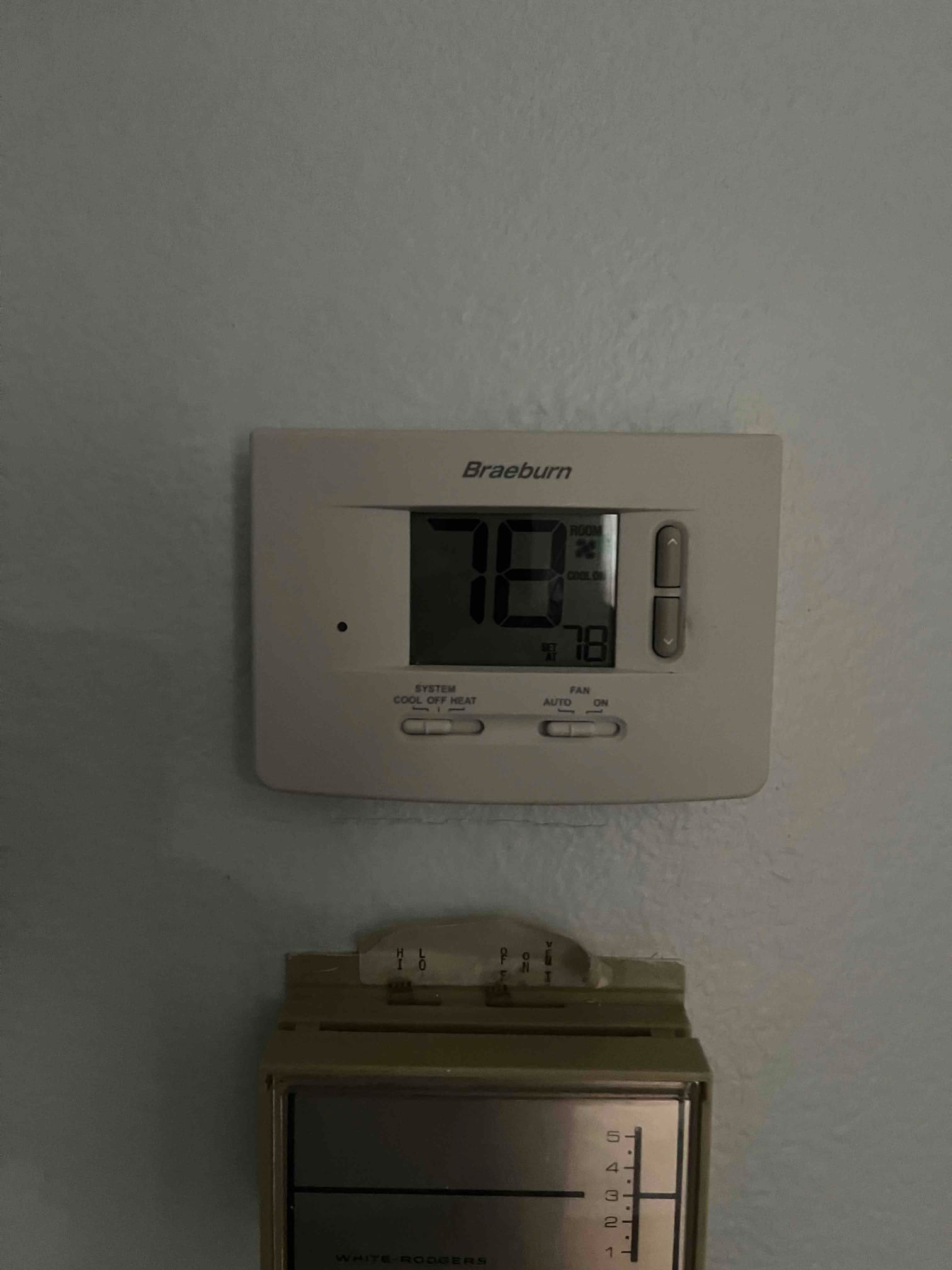 Wall-mounted digital thermostat displays 78°F with system set to 78°F, showing mode and fan settings beside the screen.