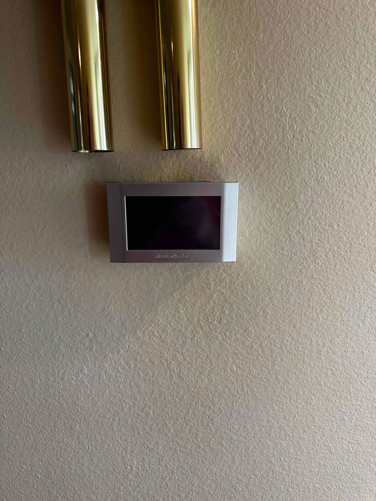 Wall-mounted digital thermostat installed cleanly, centered on the wall with display screen ready for setup.