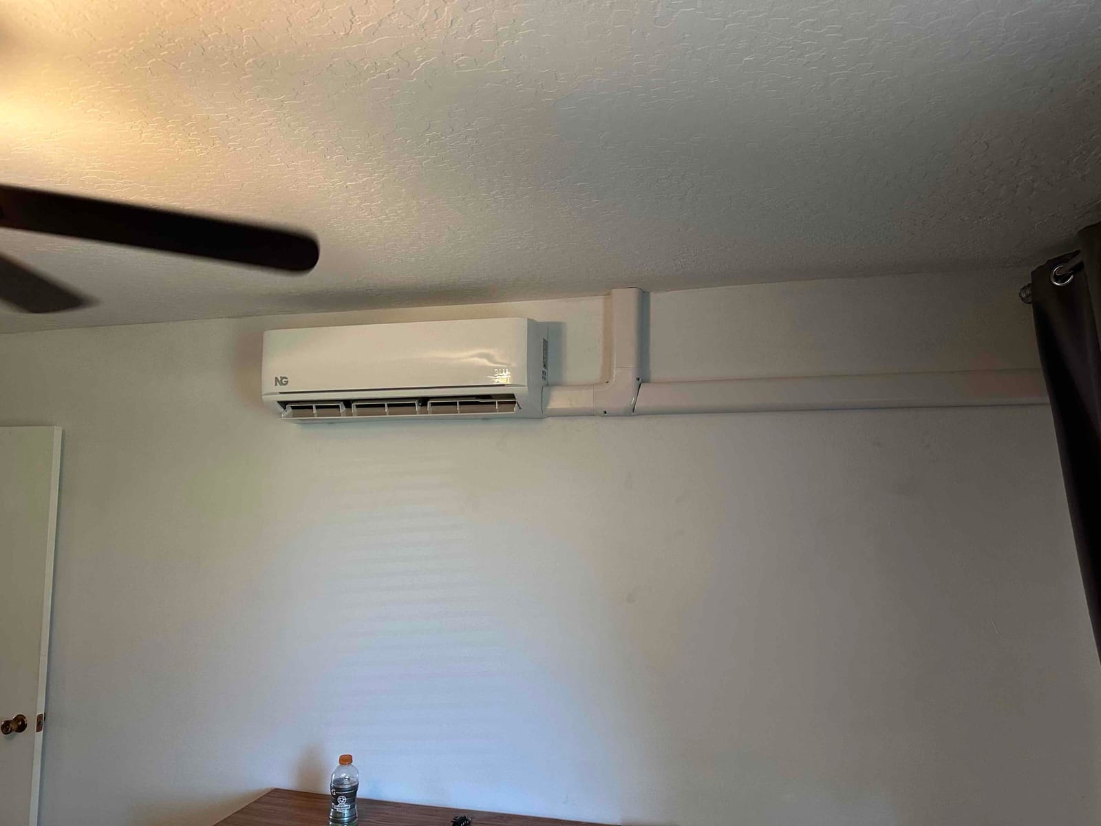 Wall-mounted mini-split indoor unit installed with surface line-set cover routed along the wall for a clean finish.