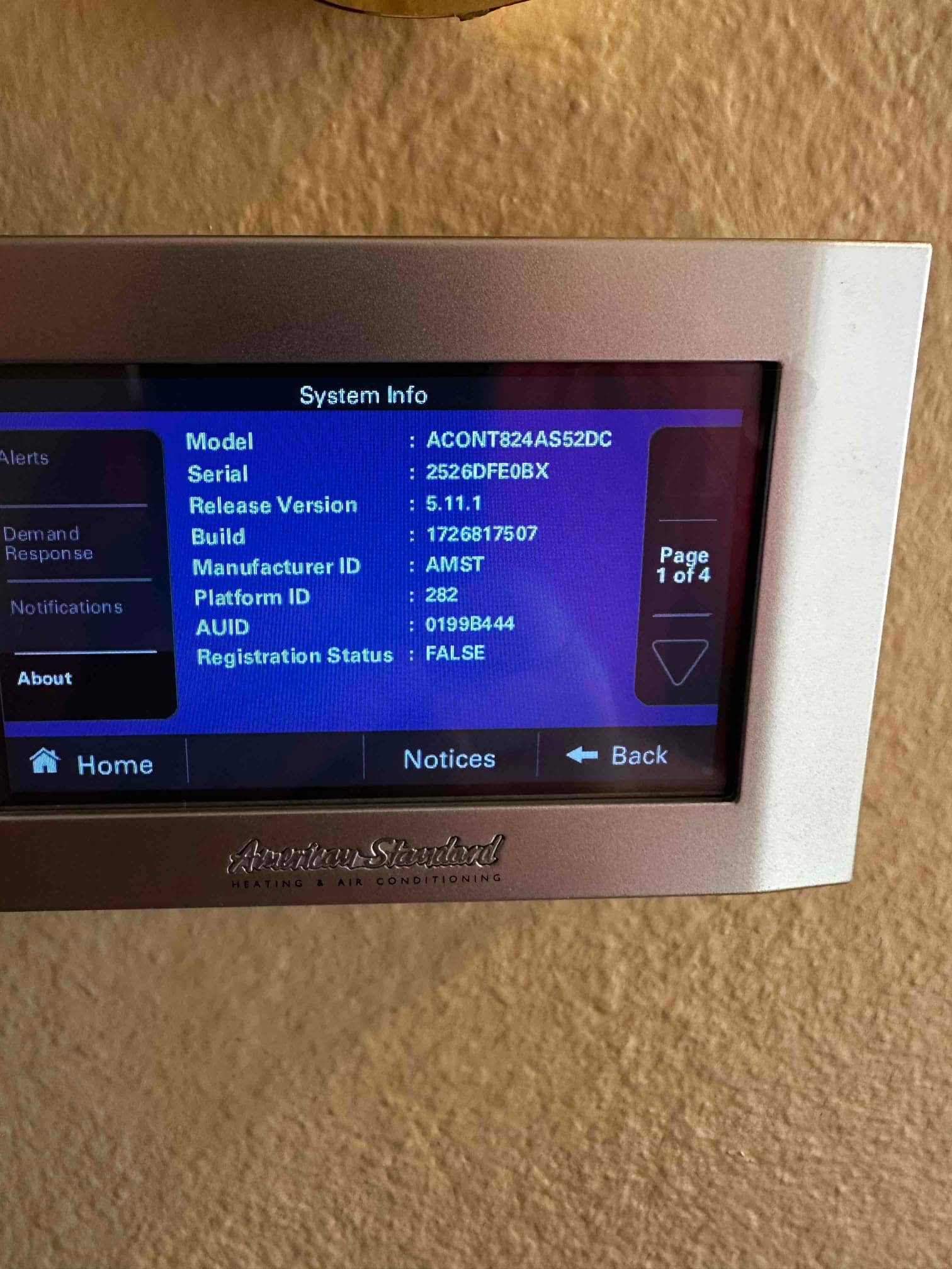 Wall-mounted touchscreen thermostat displays system information menu during commissioning after the new installation.