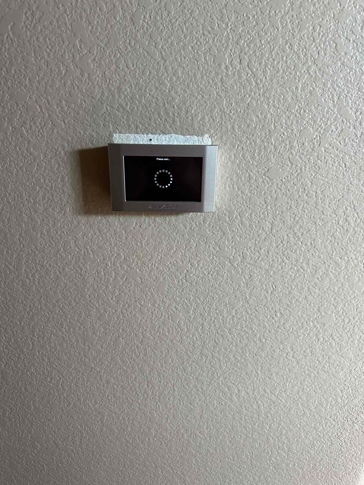 Wall-mounted touchscreen thermostat powers up with a boot screen after installation during system commissioning.