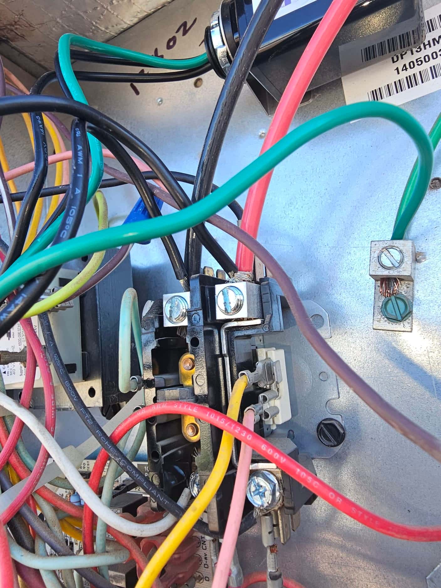 Condenser contactor and wiring compartment showing multiple connected leads on screw and spade terminals.