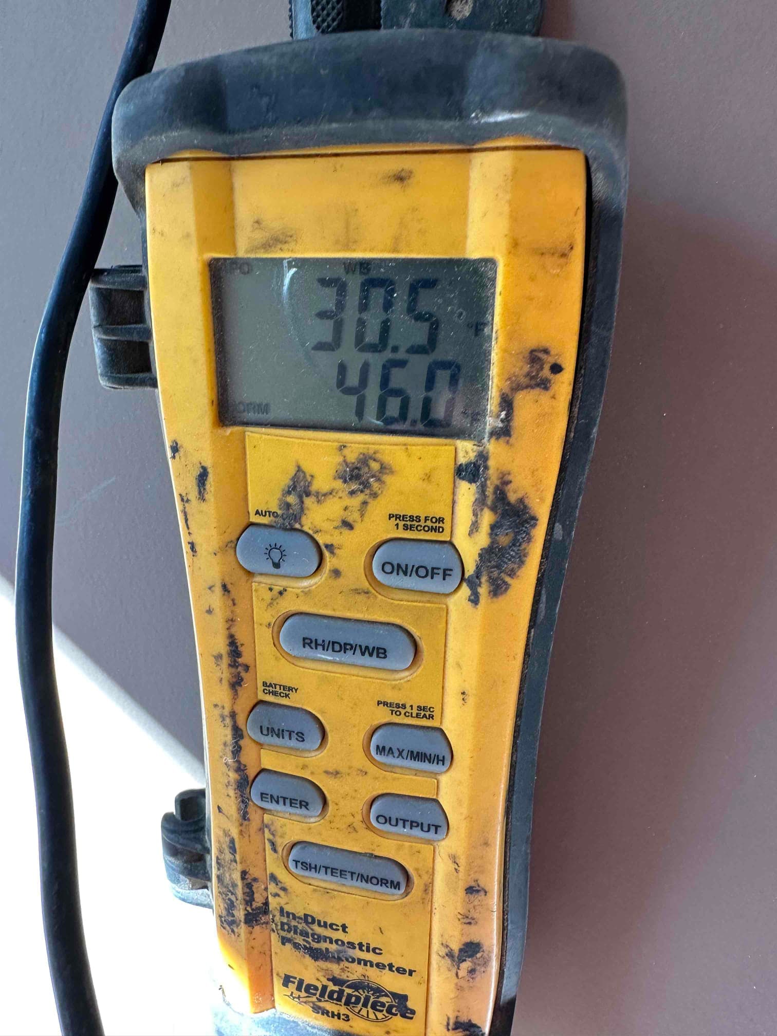 Digital diagnostic thermometer displays air temperature readings during commissioning, with clear values shown on the screen for documentation.
