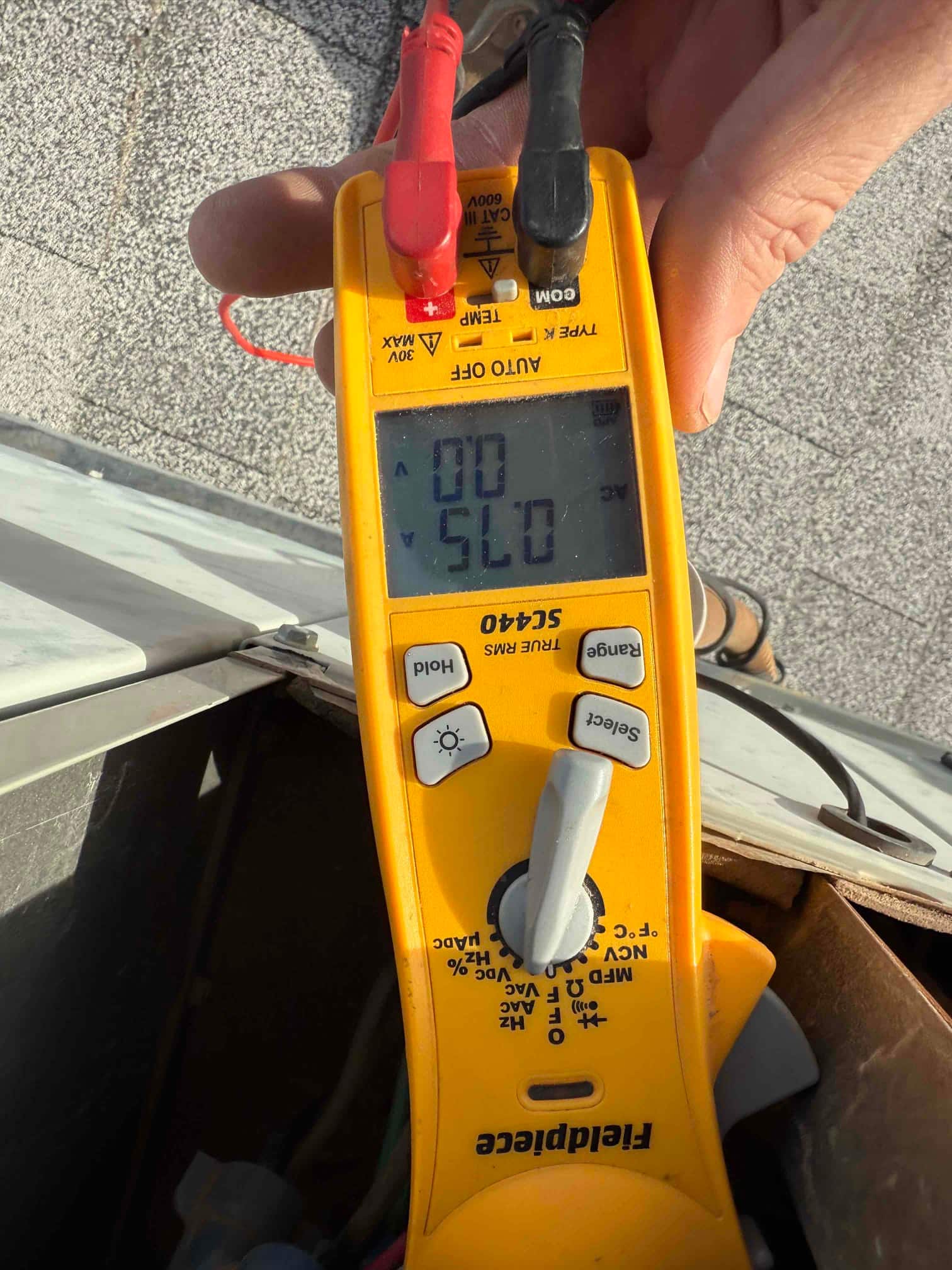 Digital multimeter set to ohms shows 0 Ω while the leads contact a component inside the disconnect box.