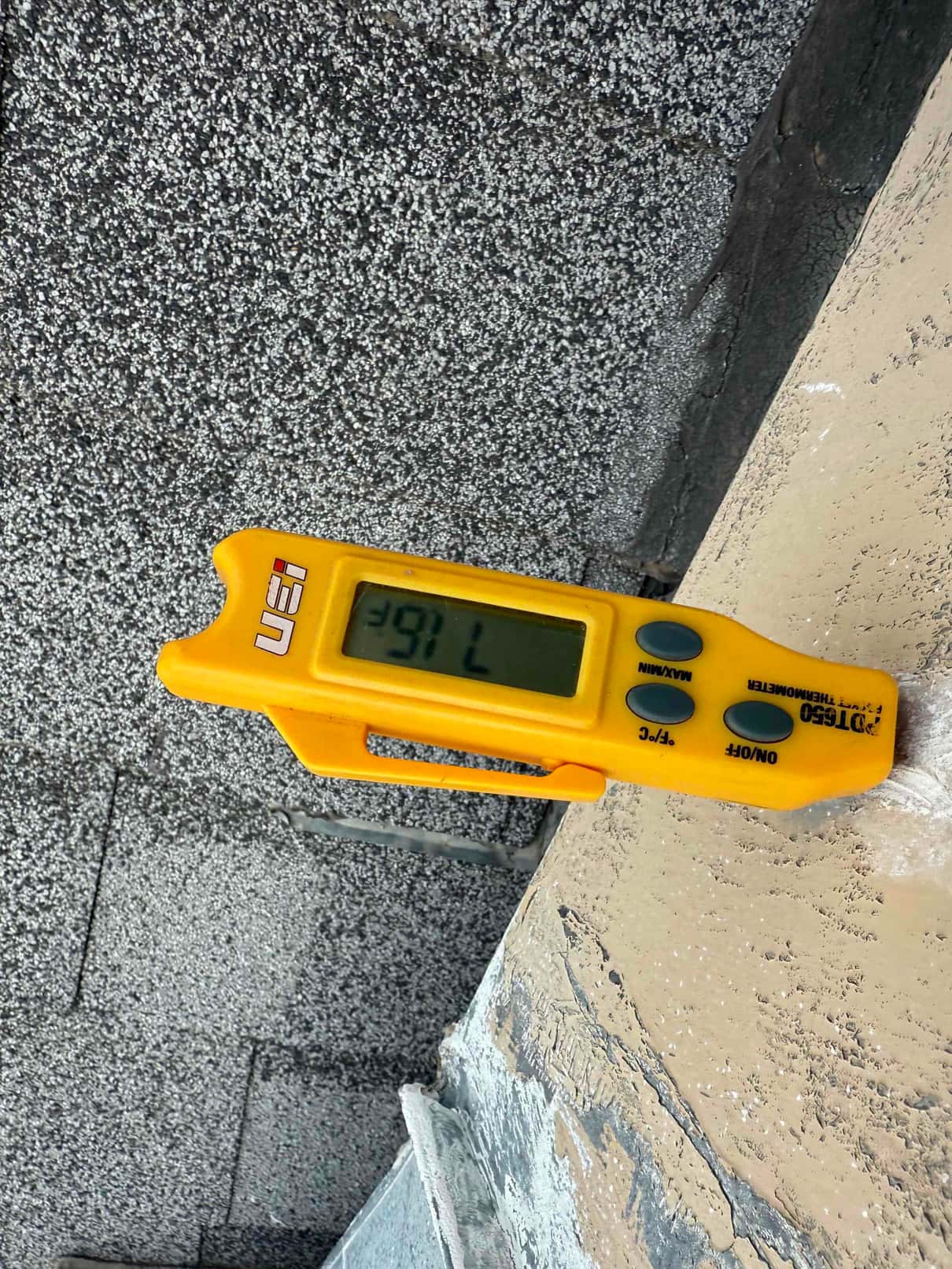 Digital thermometer displays 39.7 °F while measuring temperature at the repair site during air conditioning service.
