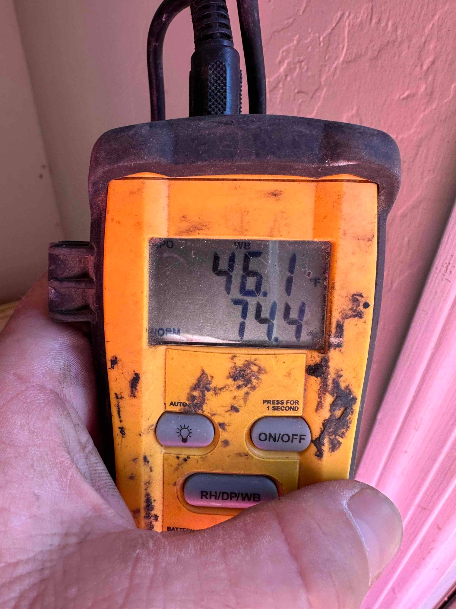 Digital thermometer displays 46.1°F and 74.4°F during air temperature checks on the newly installed HVAC system.