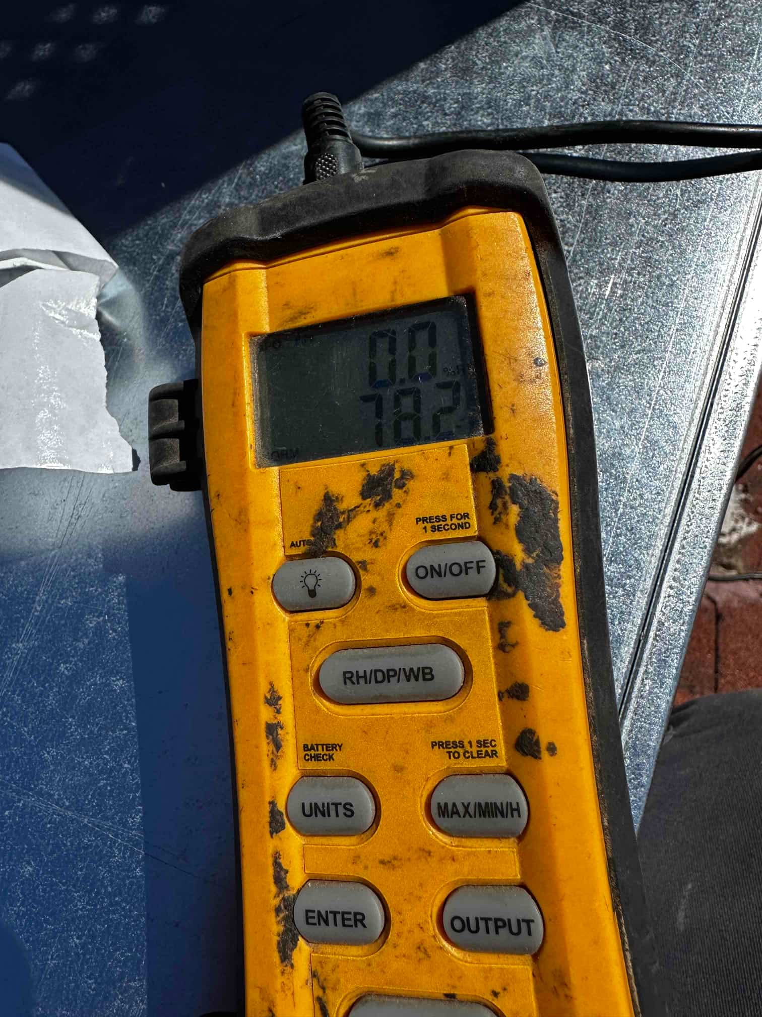 Digital thermometer displays 78.2 degrees, documenting return air temperature during commissioning of the new cooling system.