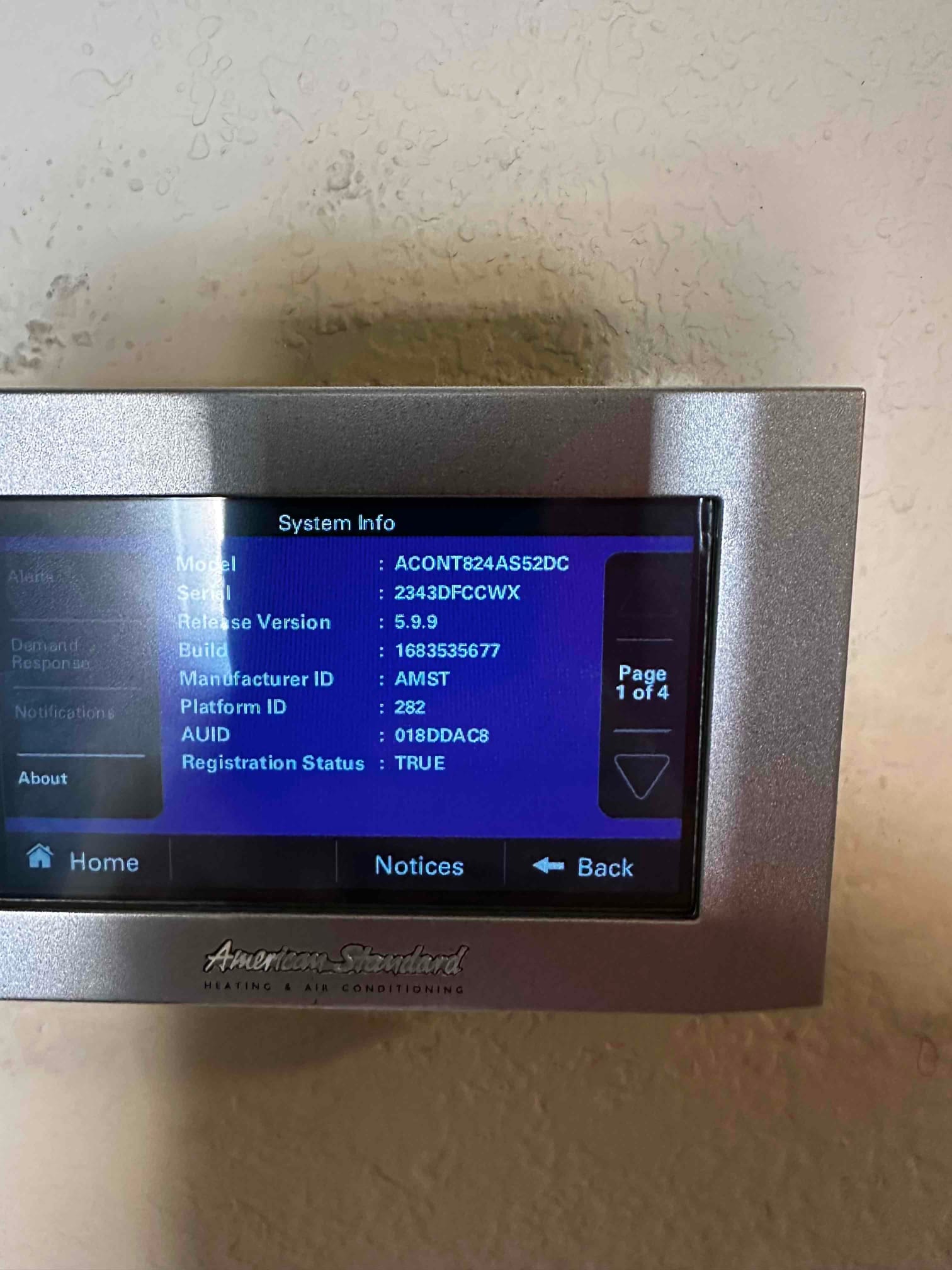 Thermostat system info screen displayed after installation, showing device software and registration details on the wall-mounted controller.