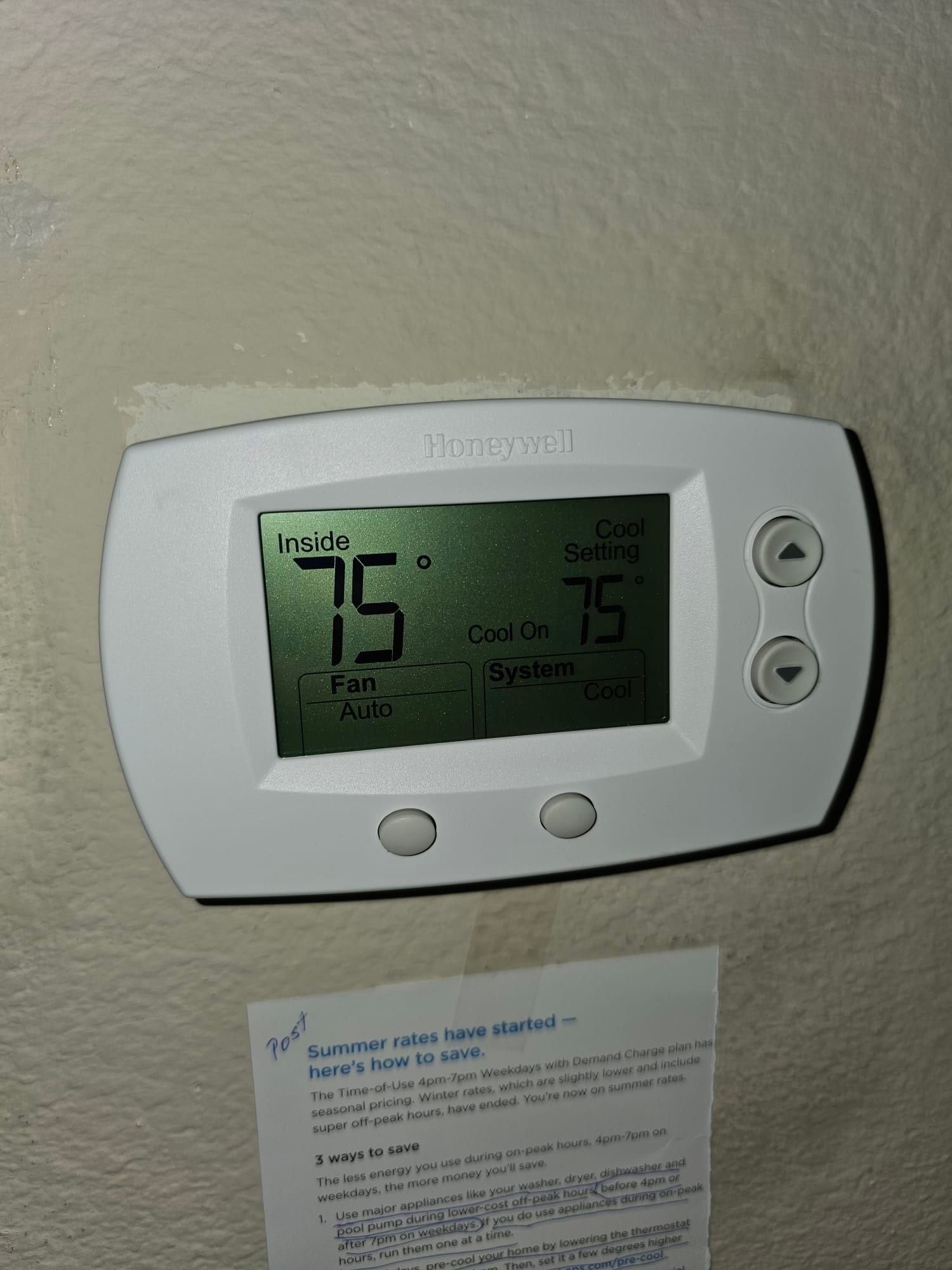 Wall-mounted digital thermostat shows inside temperature 75°F and cool setpoint 75°F, fan set to Auto.
