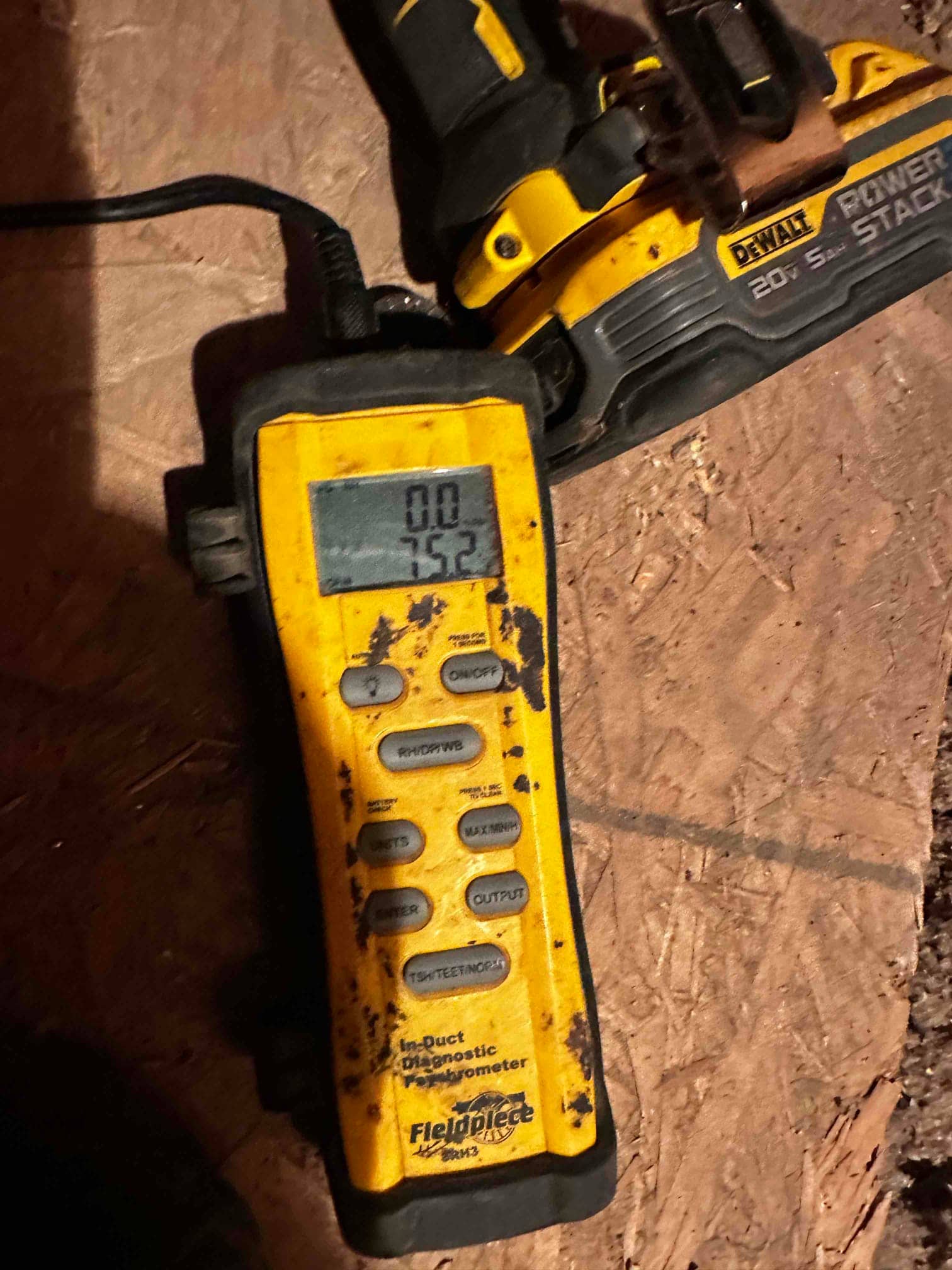 Digital in-duct hygrometer displays 75.2 on screen during airflow and comfort verification after installation.