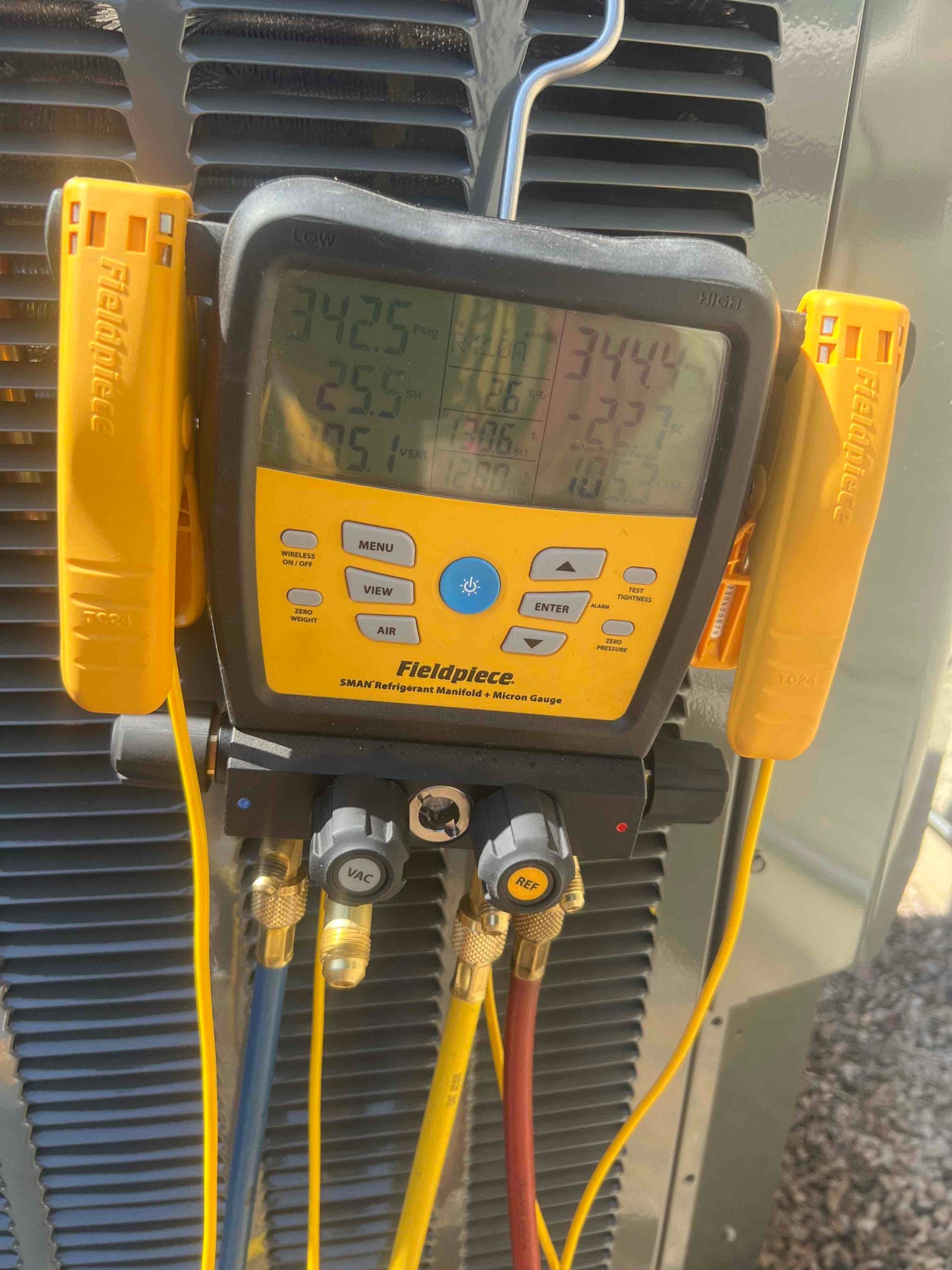 Digital manifold gauges show equal pressures around 344 PSI on both sides during a nitrogen pressure test of the new system.