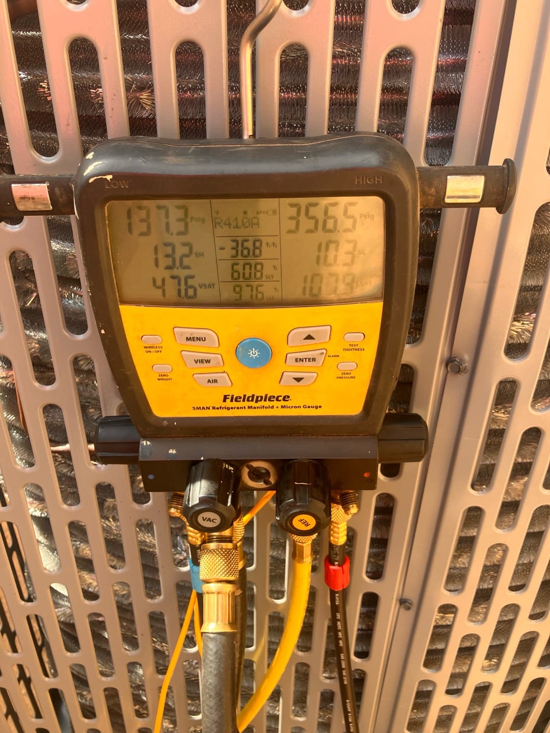 Digital manifold on the outdoor unit shows operating pressures of 137 PSIG suction and 356 PSIG liquid with superheat and subcooling displayed.