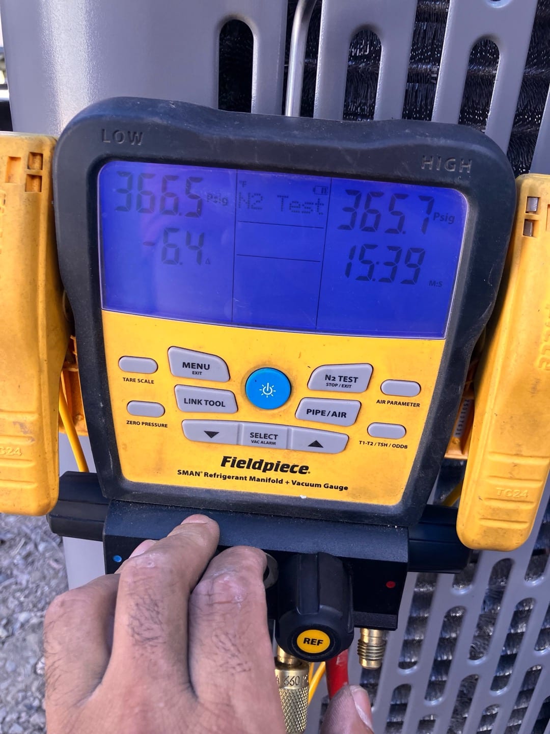 Digital manifold shows equal pressures around 366 PSI on both sides during a nitrogen pressure test at the outdoor unit.