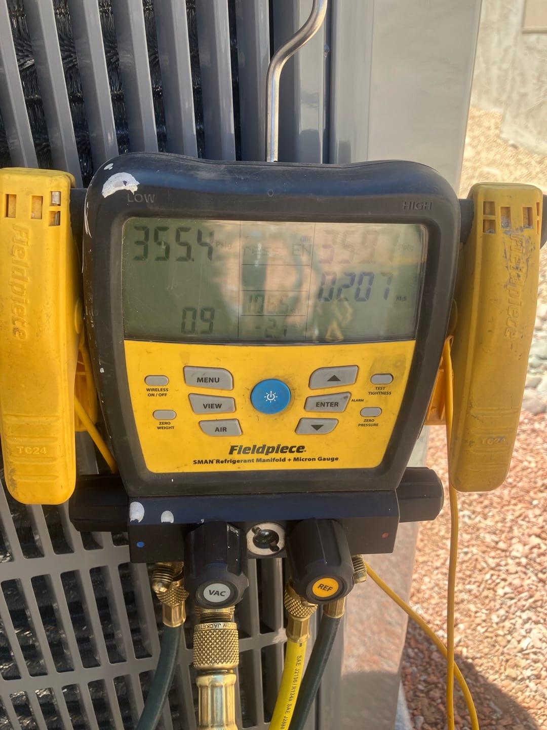 Digital manifold shows both high and low sides holding equal pressure during a nitrogen pressure test on the outdoor unit.