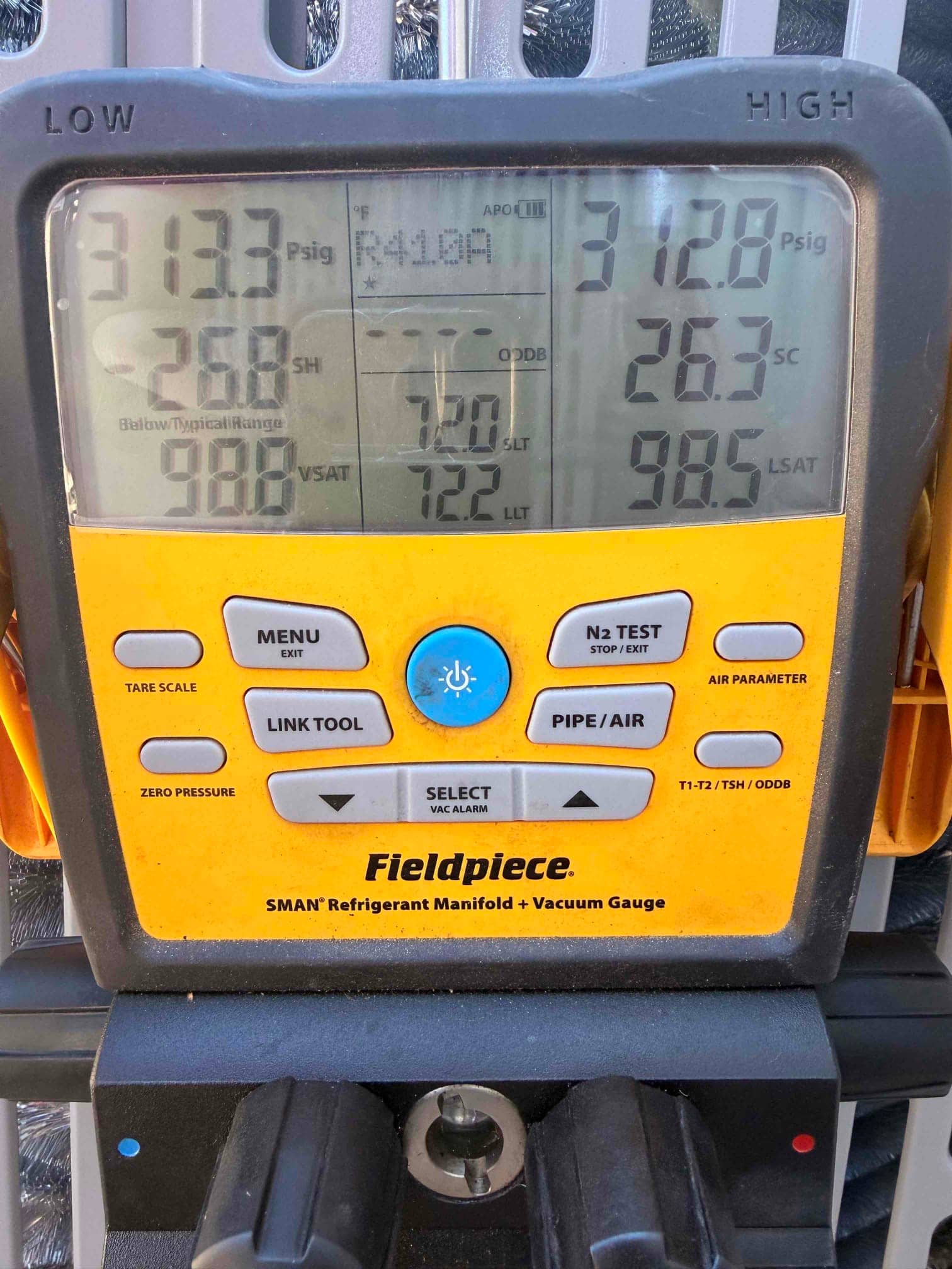 Digital manifold shows operating pressures with low side at 313 PSI and high side at 312 PSI during system commissioning.