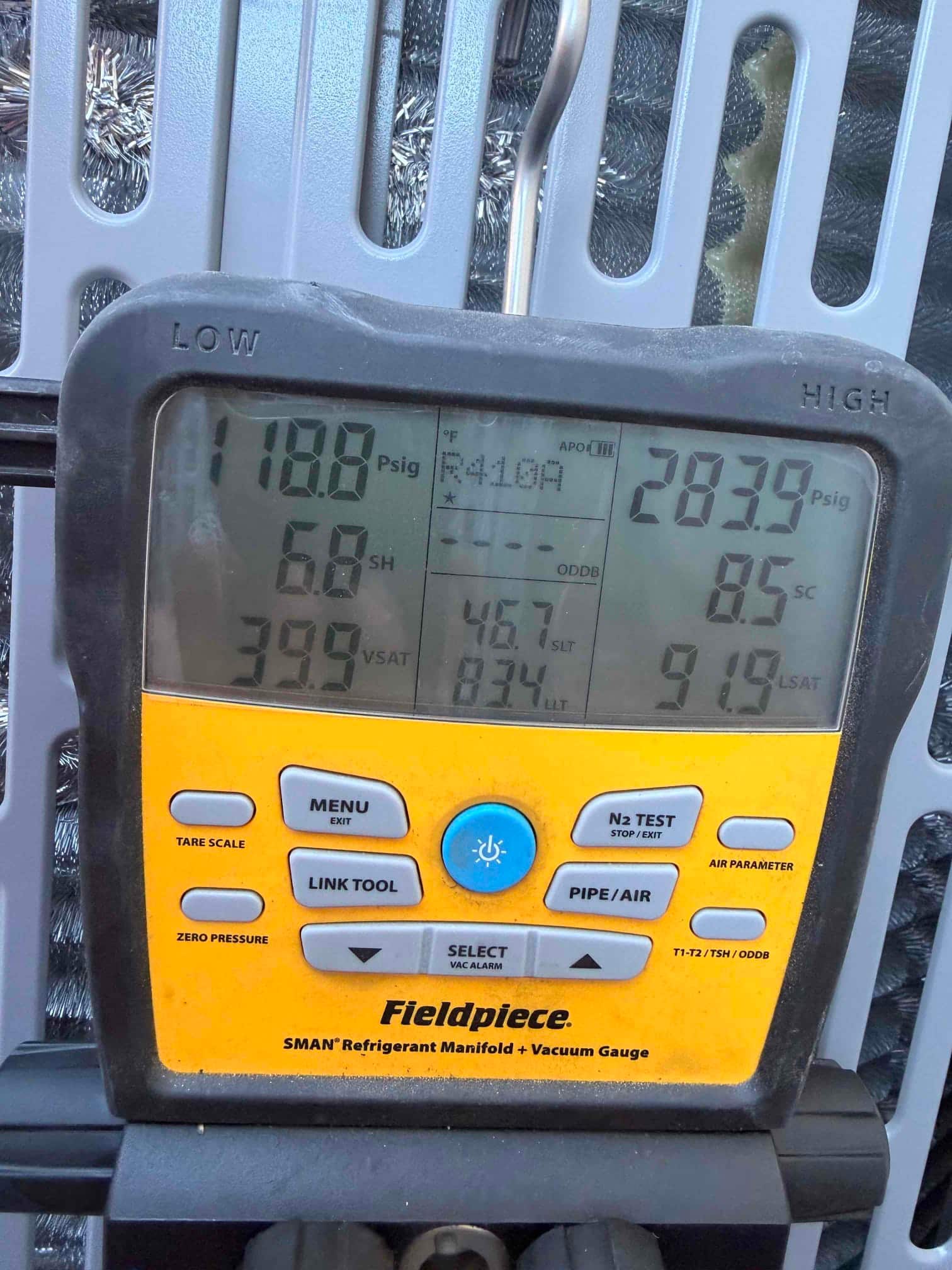 Digital manifold shows system operating with 118 PSIG suction and 284 PSIG liquid pressure on an R-410A installation.