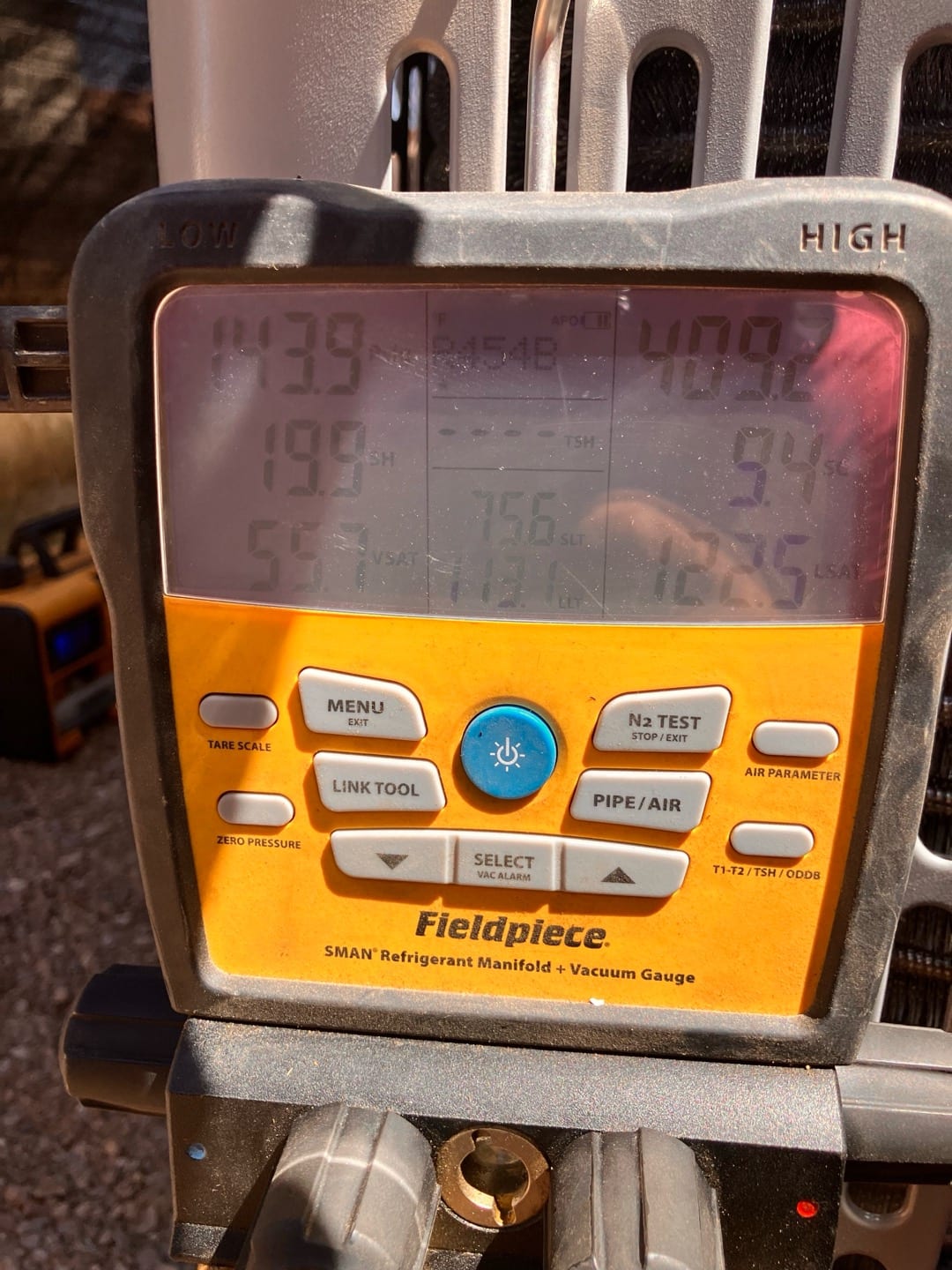 Digital manifold shows system operating with low side at 143 PSI and high side at 409 PSI using R-454B refrigerant.