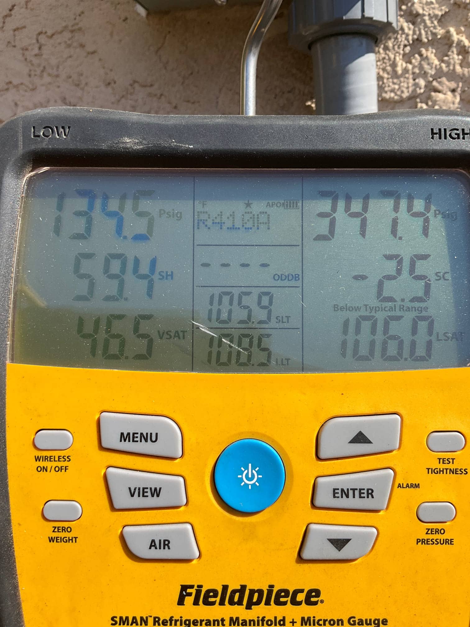 Digital manifold shows system operating pressures with R-410A selected: low side 134.5 PSI and high side 347.4 PSI.