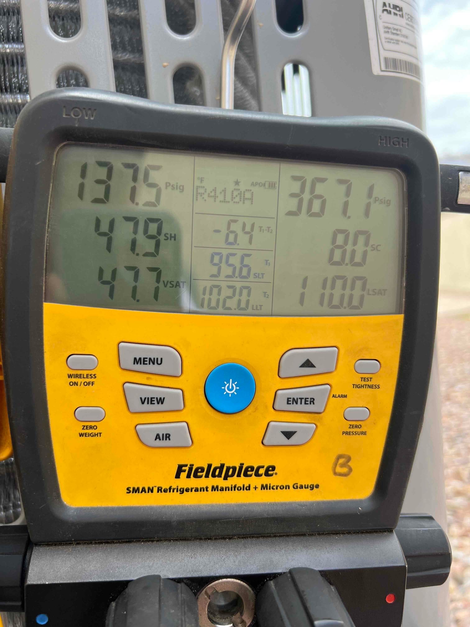 Digital manifold shows system operating pressures and calculated values while commissioning the newly installed air conditioning system.