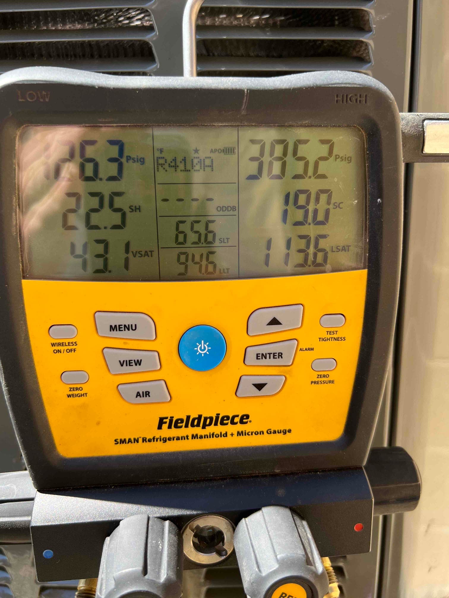 Digital manifold shows system operating pressures with low side at 126.3 PSI and high side at 385.2 PSI on R‑410A.