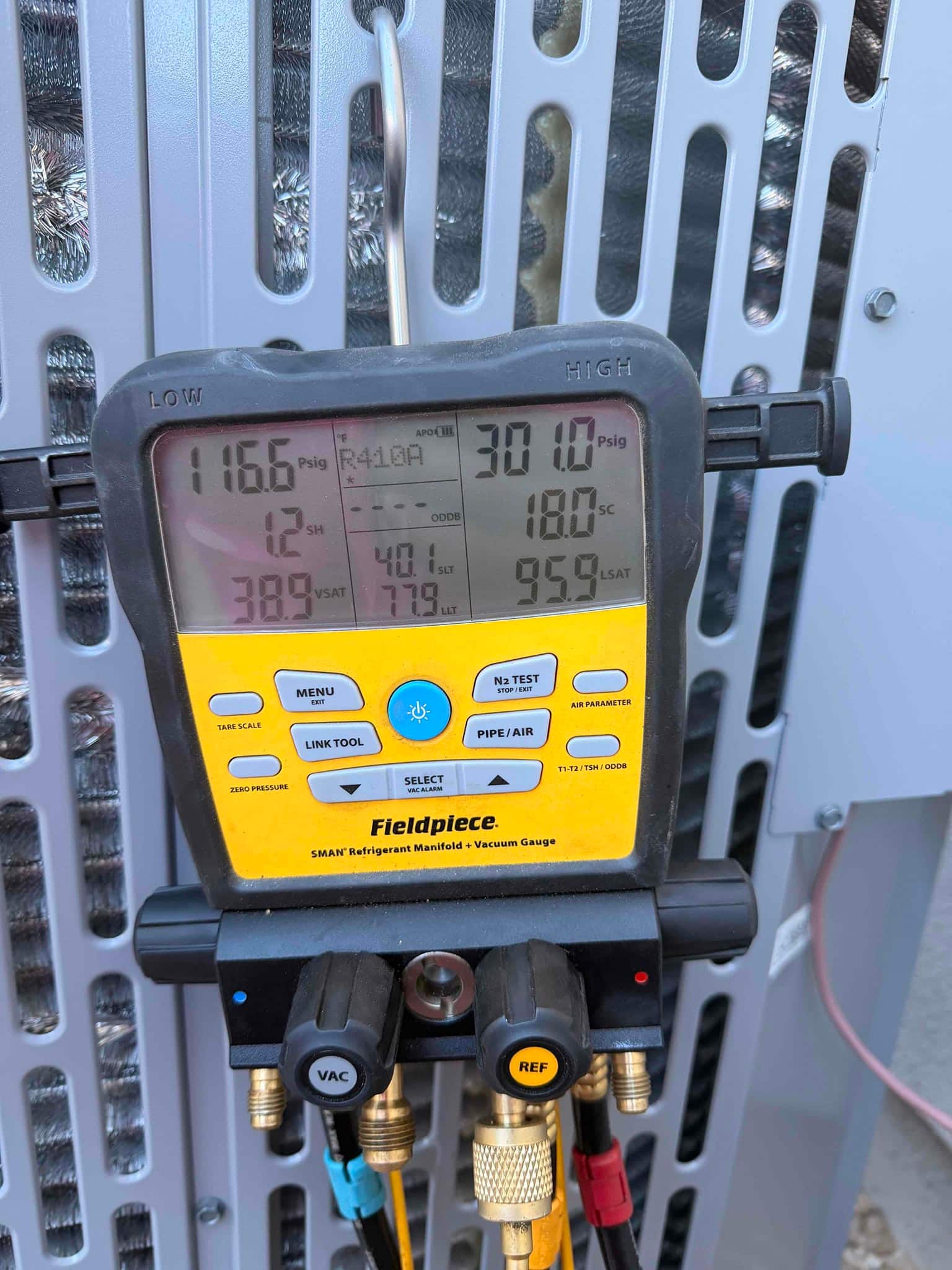 Digital manifold shows system operating pressures with superheat and subcooling while connected at the outdoor condenser.