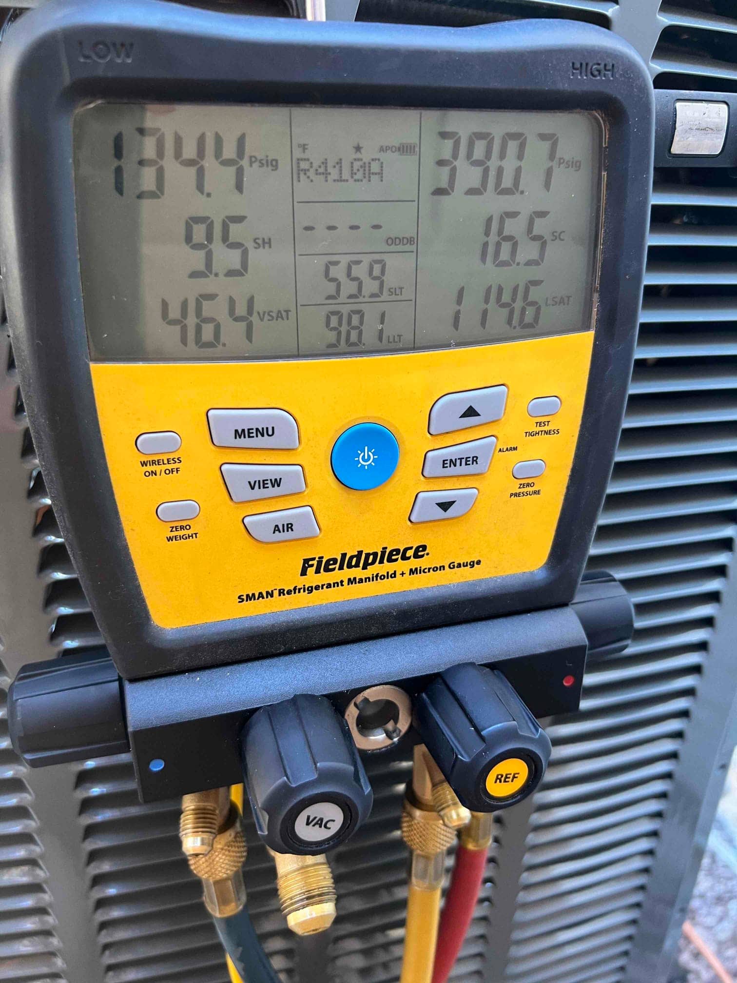 Digital manifold shows system operating pressures and temperatures during commissioning at the outdoor unit.