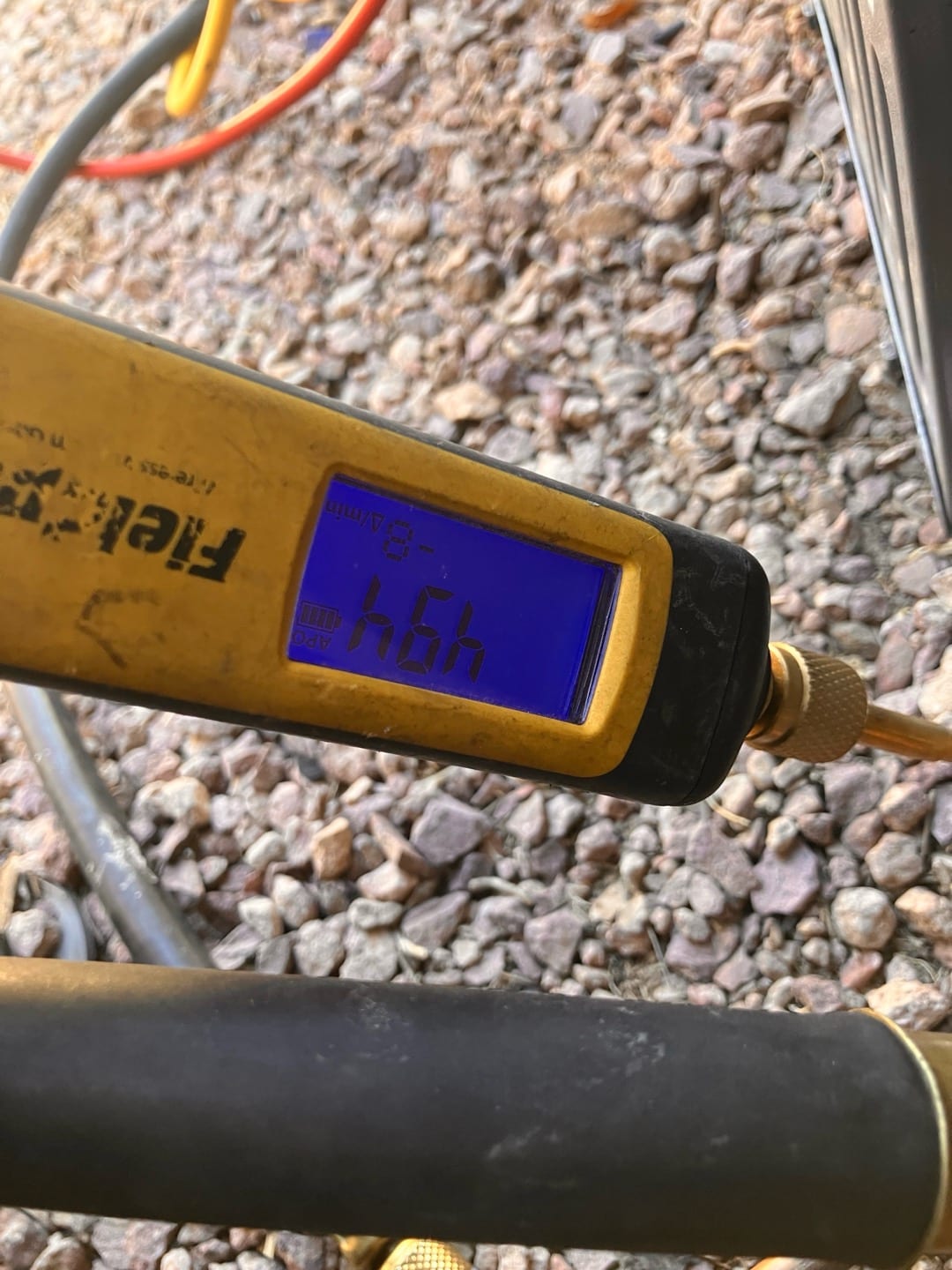 Digital micron gauge connected to the system shows a deep vacuum during evacuation before refrigerant charging.