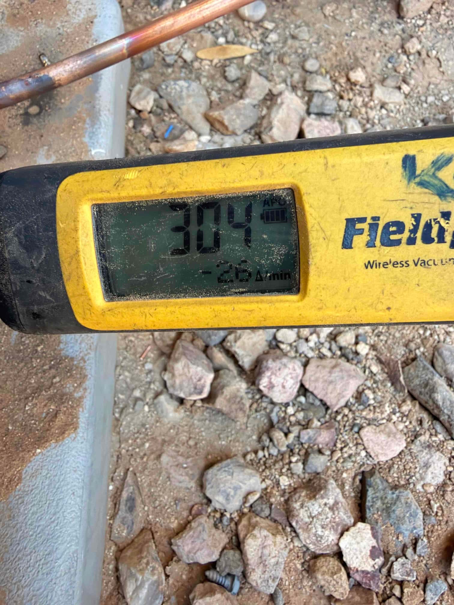 Digital micron gauge shows 304 microns during system evacuation on newly installed refrigerant lines.