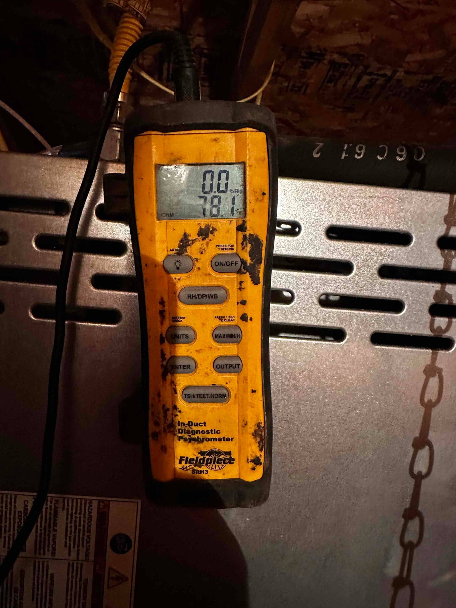 Digital psychrometer shows 78.1 degrees on top of the air handler during airflow and temperature checks.