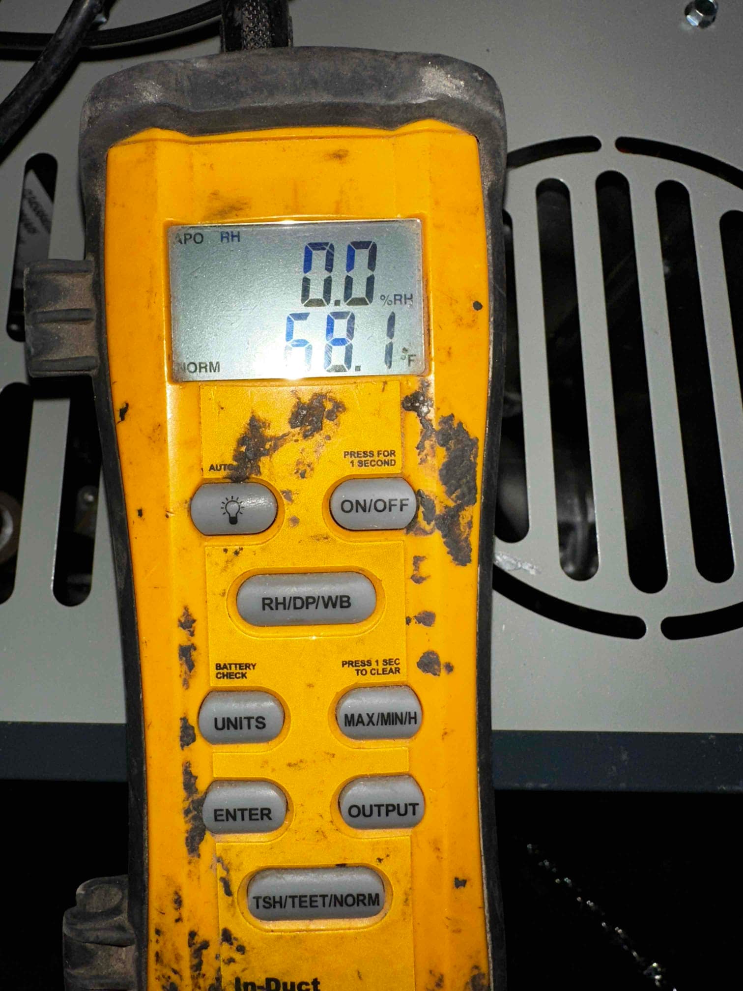 Digital thermometer displays 58.1 degrees Fahrenheit, documenting cool supply air temperature during commissioning.