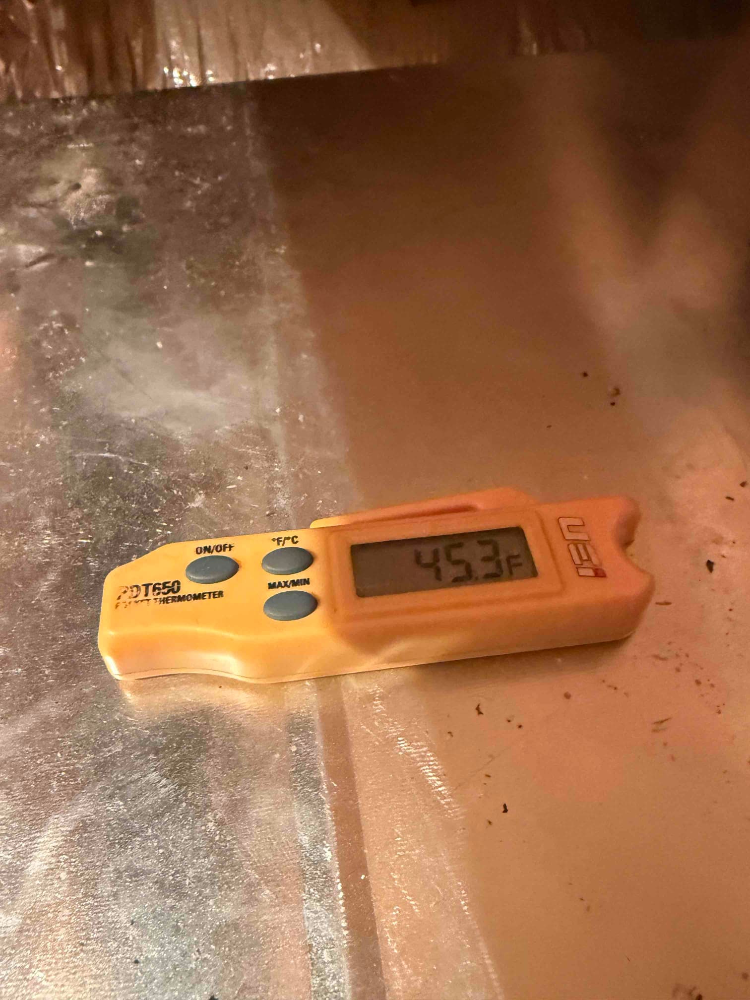 Digital thermometer on duct surface displays 45.3°F, documenting cold air temperature during system air-side testing.