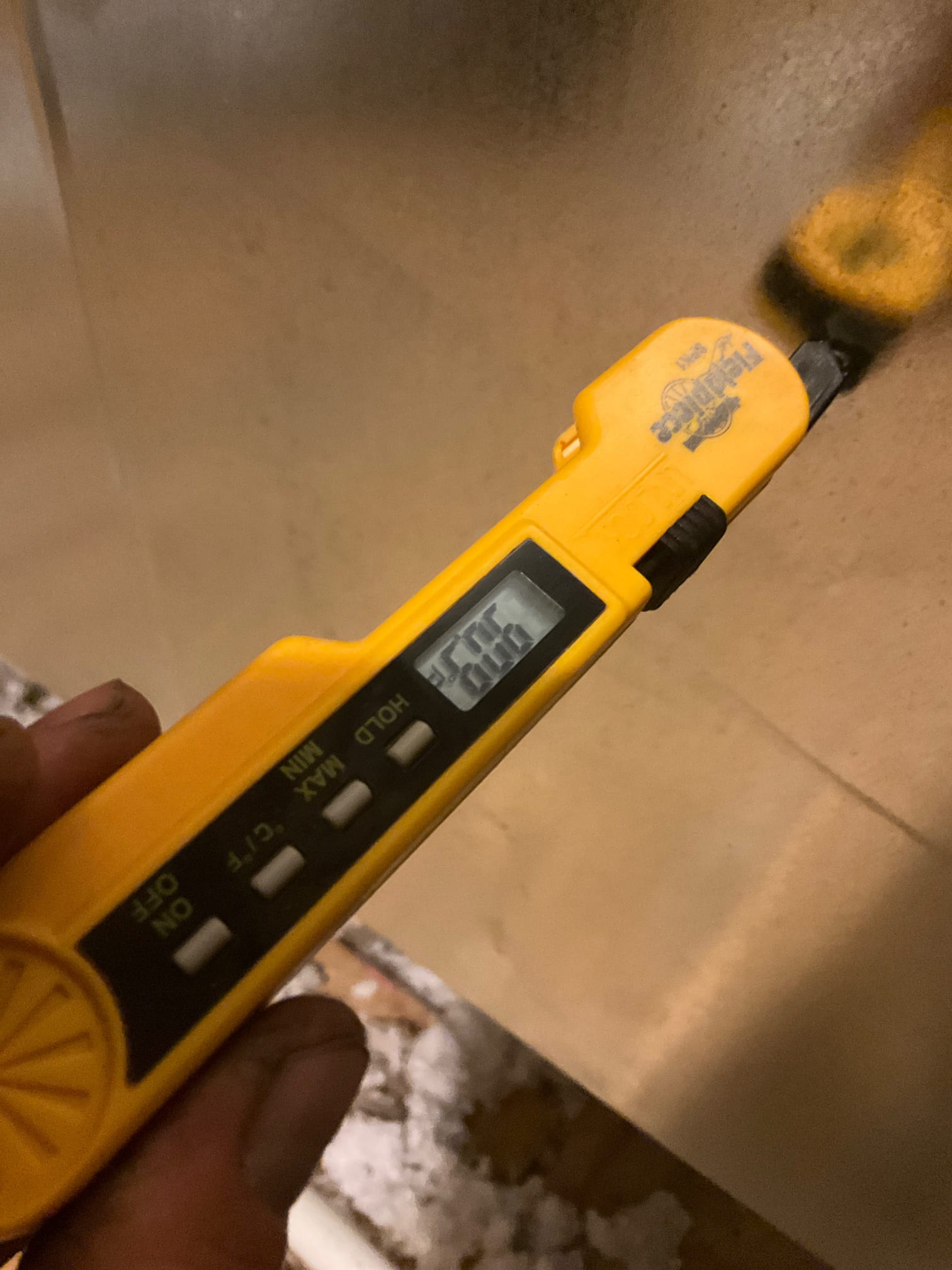 Digital thermometer inserted into duct surface shows 78.0 degrees Fahrenheit, documenting return air temperature during commissioning.