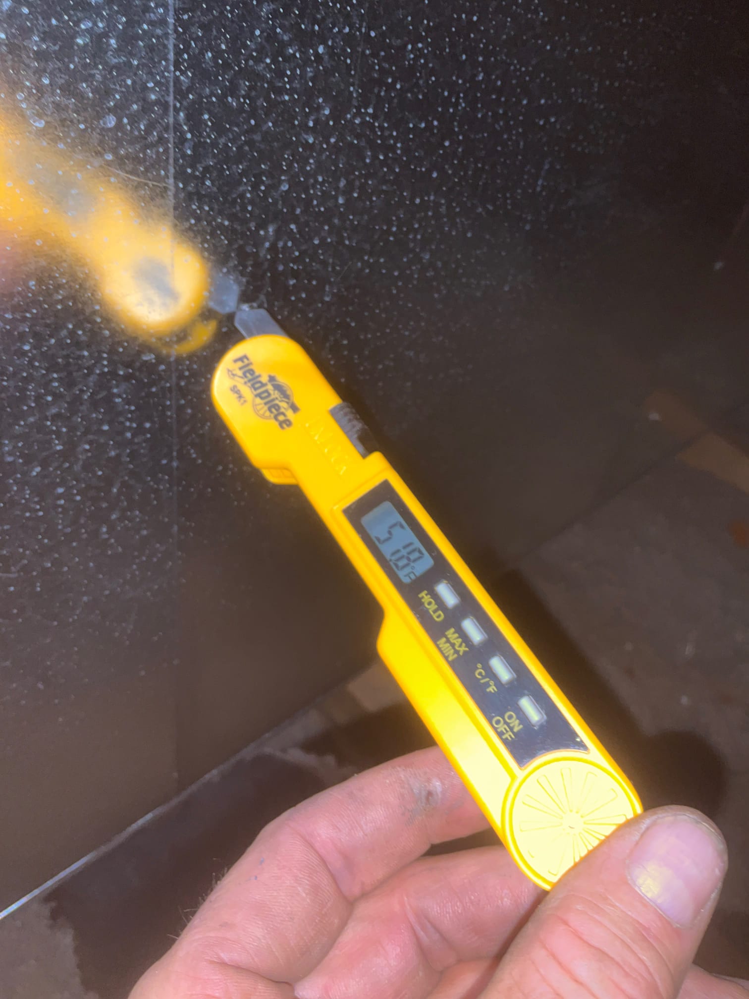 Digital thermometer probe measures 51.0°F on the supply air surface during cooling checkout.