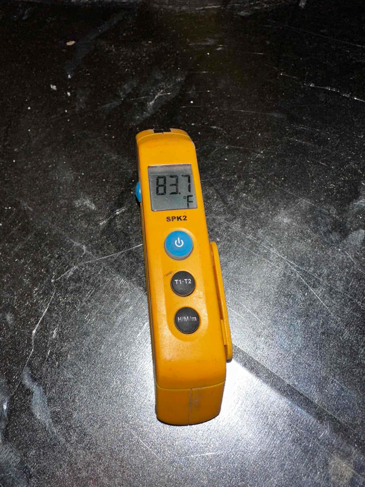 Digital thermometer reads 83.7°F during air temperature check as part of commissioning.