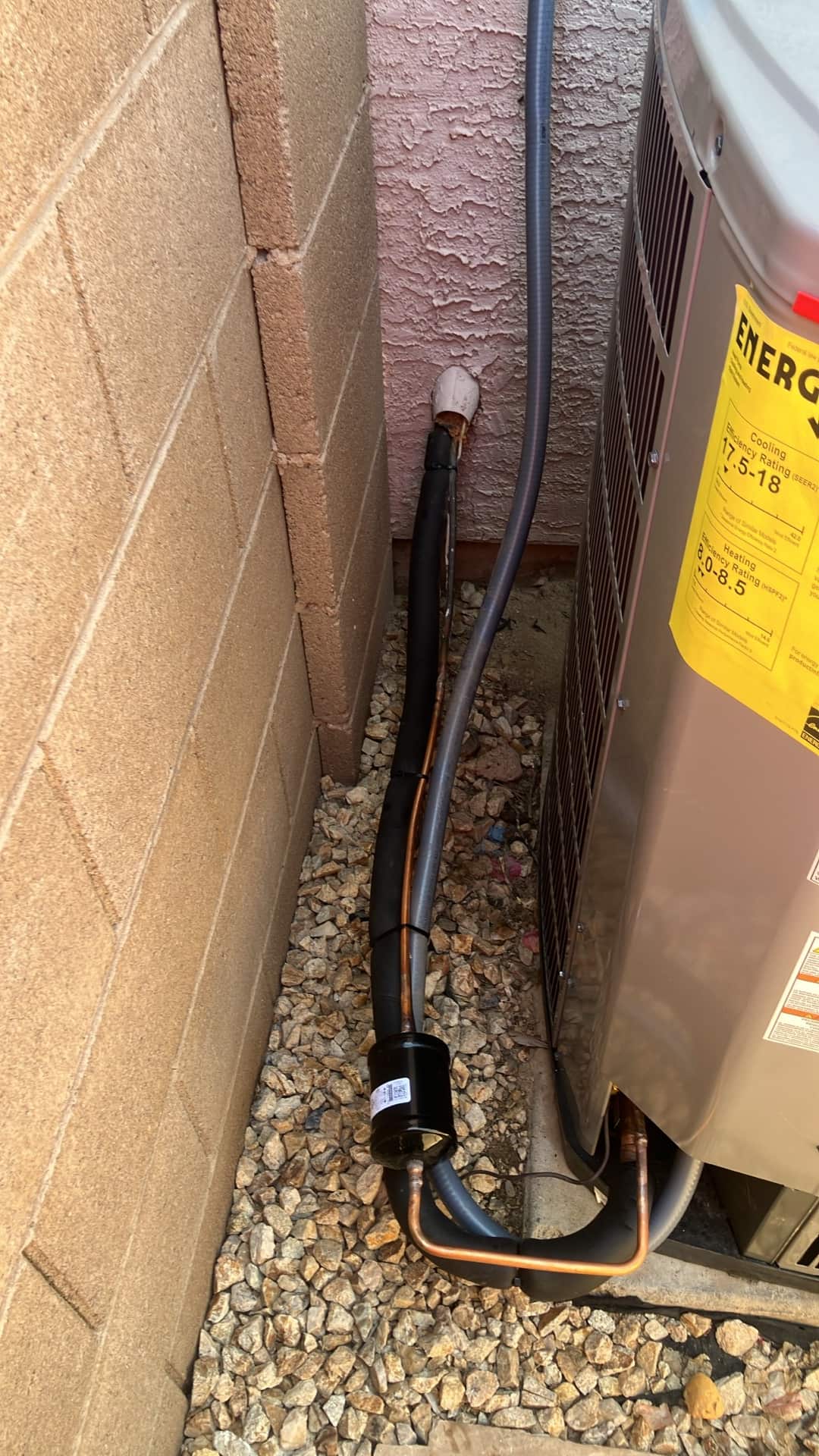Insulated refrigerant line set with filter-drier connected to the outdoor condenser, sealed wall penetration, and flexible electrical whip routed.