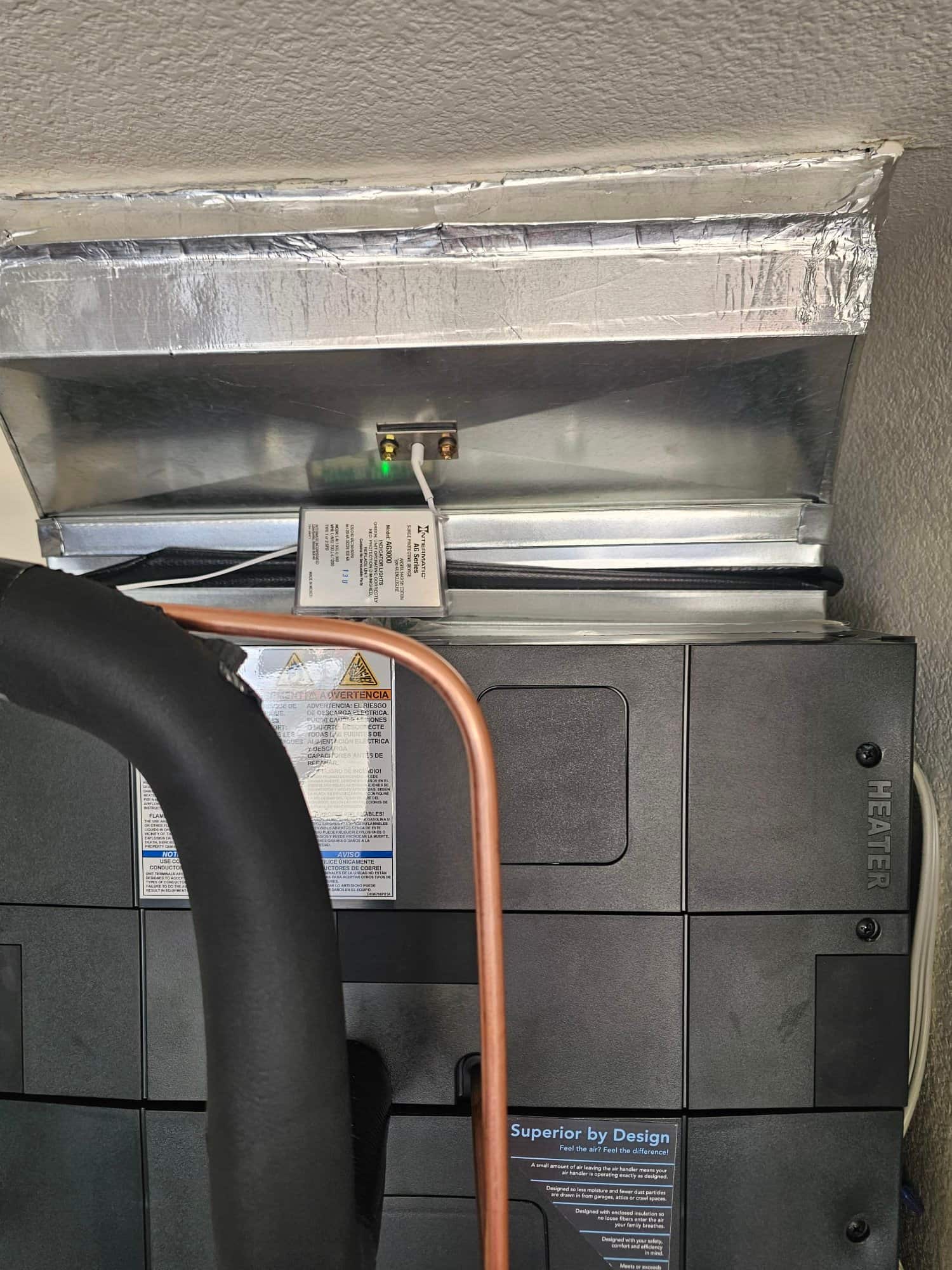 New air handler with sealed sheet metal plenum, installed refrigerant line set, and inline condensate safety switch with indicator light.