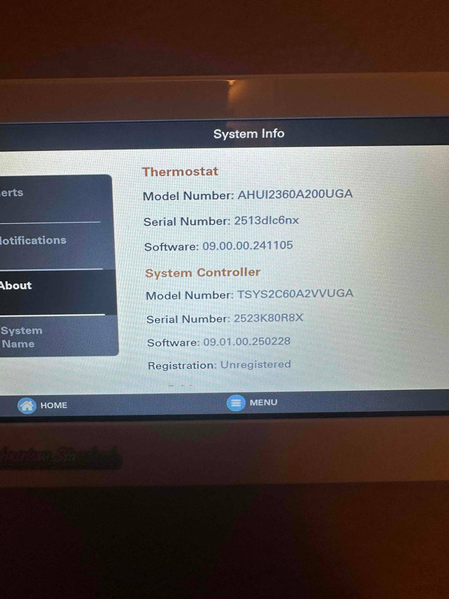 Thermostat touchscreen displays system information and software versions after installation, showing controller details and registration status on the home interface.