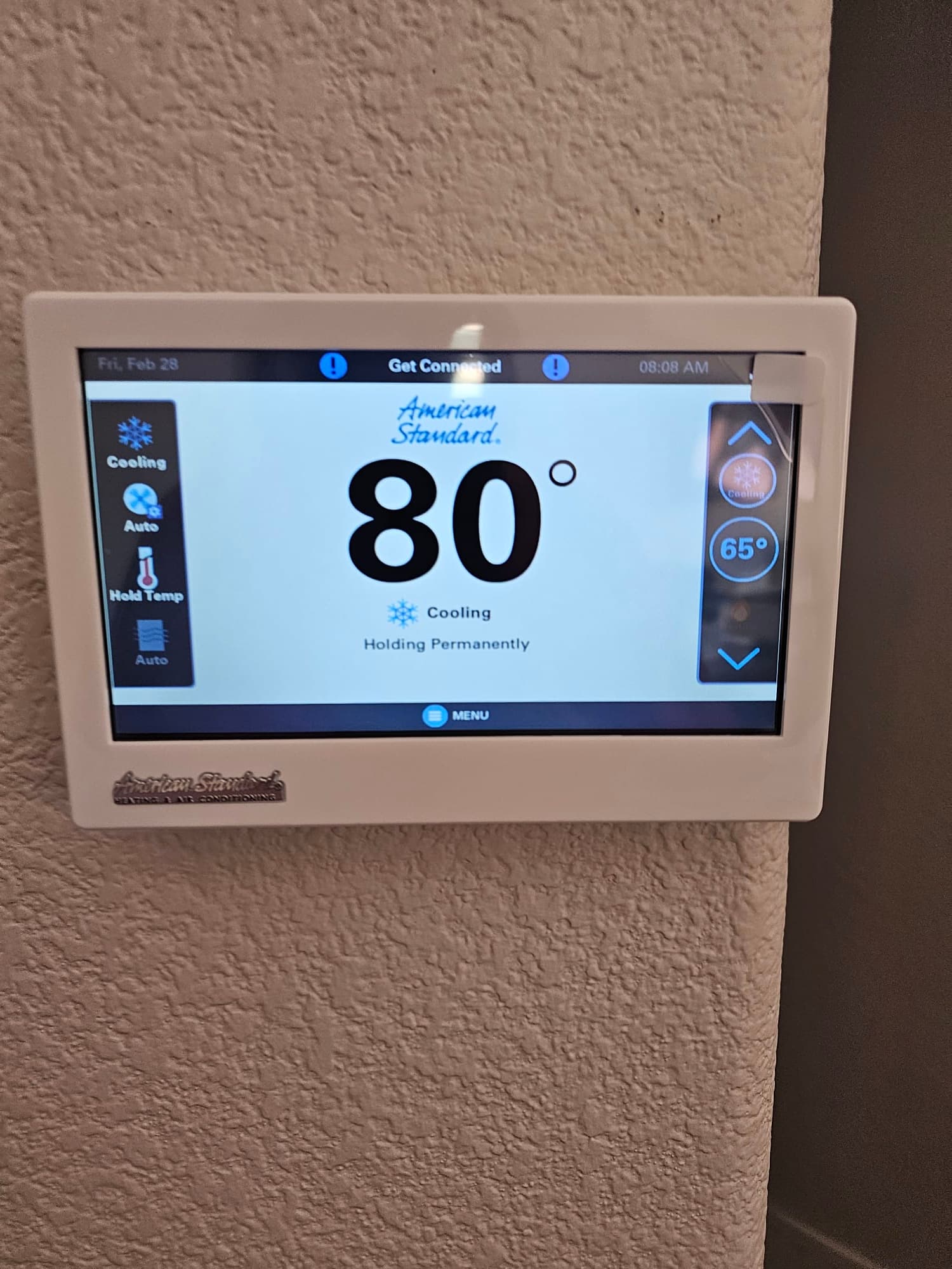 Wall-mounted touchscreen thermostat displays 80 degrees with cooling mode active and setpoint shown on the right side.